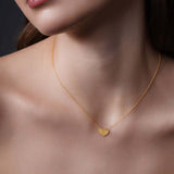 Engraved Heart Necklace displayed on model, featuring a textured heart pendant in 14k yellow gold.