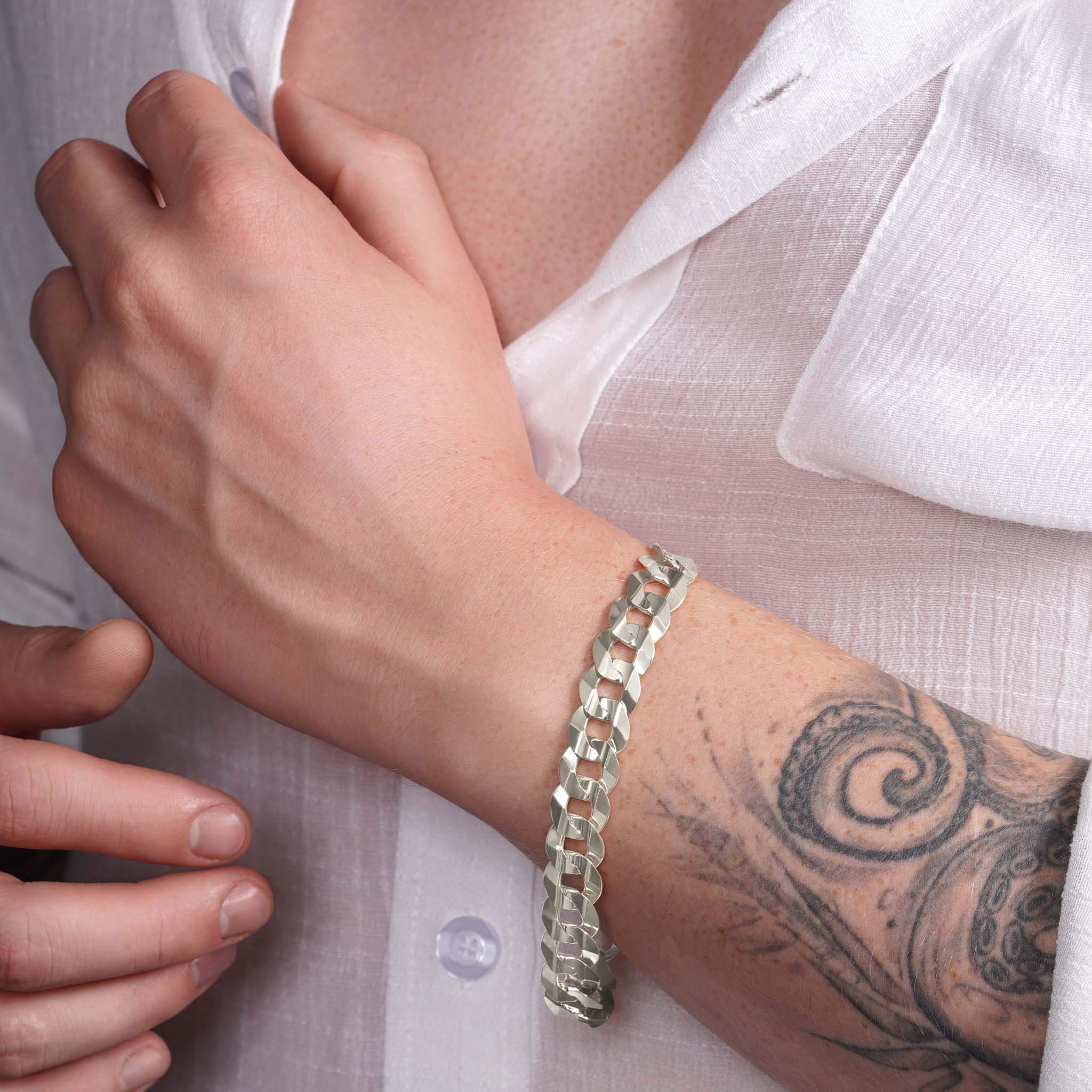 Men's solid gold curb bracelet in white gold on a wrist, showcasing classic design and elegant craftsmanship.
