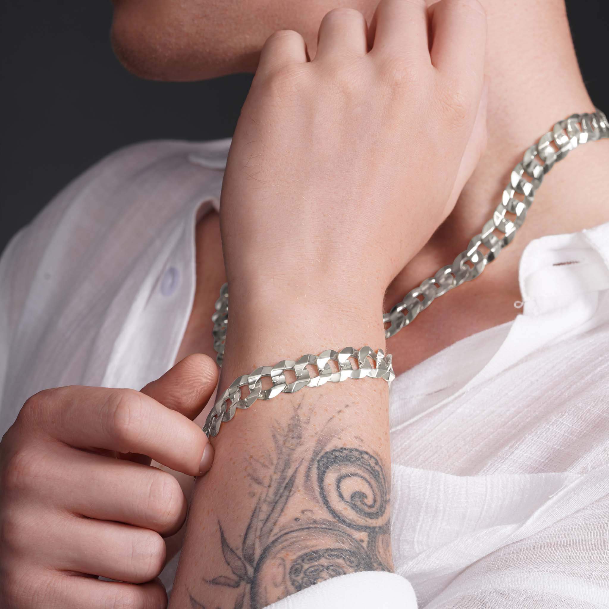 Stylish man wearing a solid gold curb bracelet and necklace, showcasing a bold and refined look.