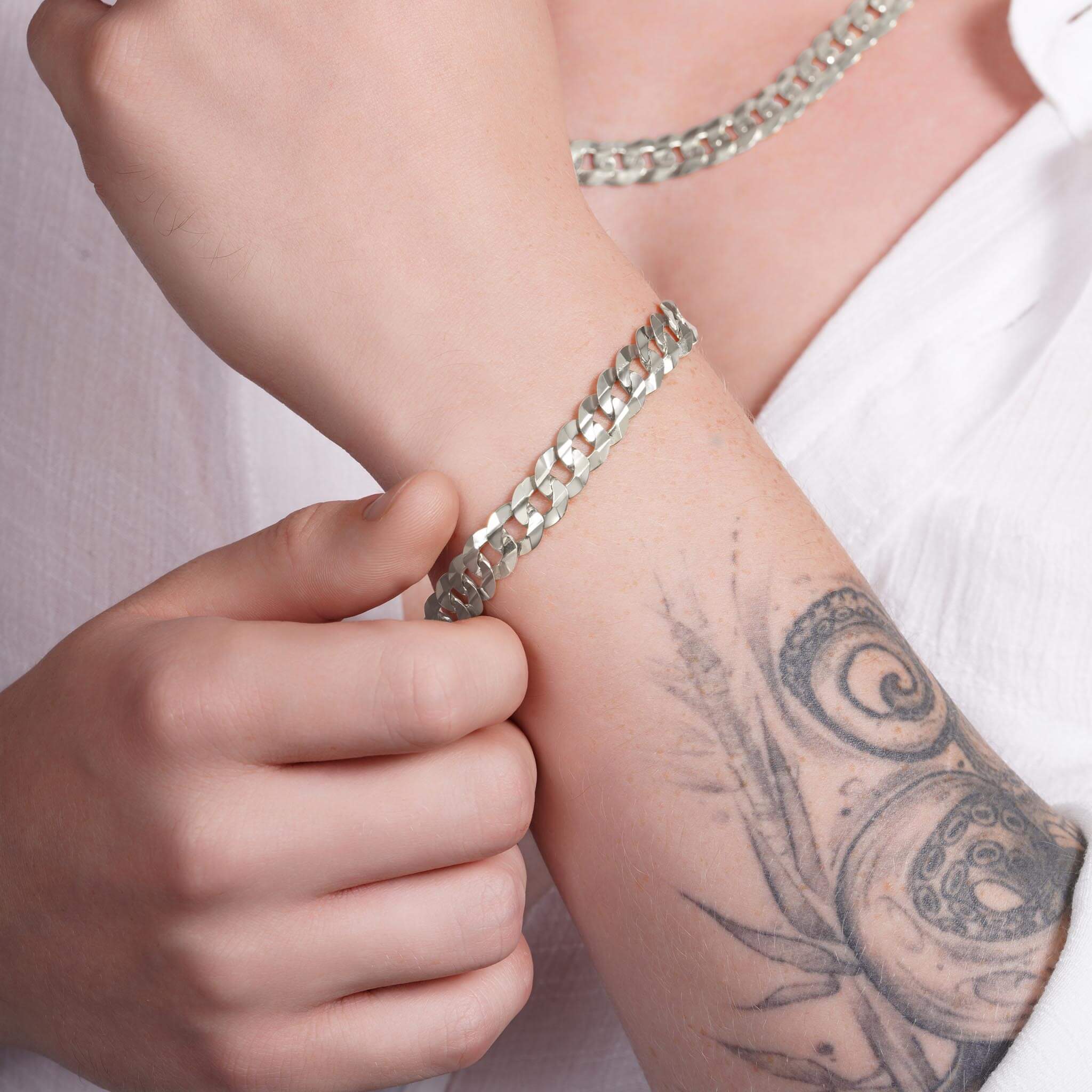 Men's solid gold curb bracelet on a wrist, showcasing a classic design and craftsmanship.