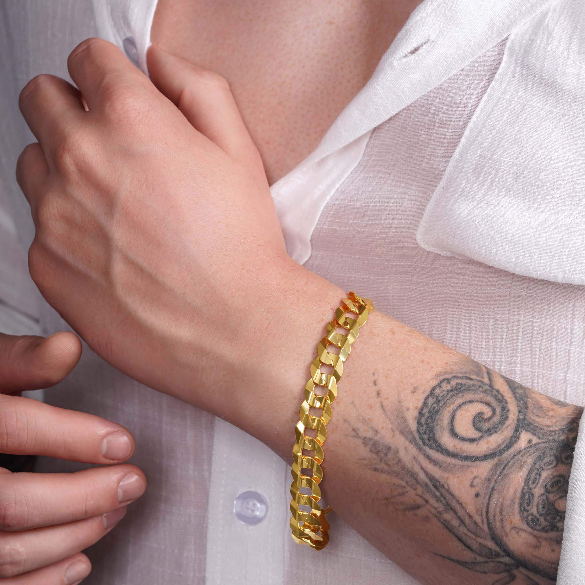 Men's solid gold curb bracelet on a wrist, featuring a classic design and durable craftsmanship.