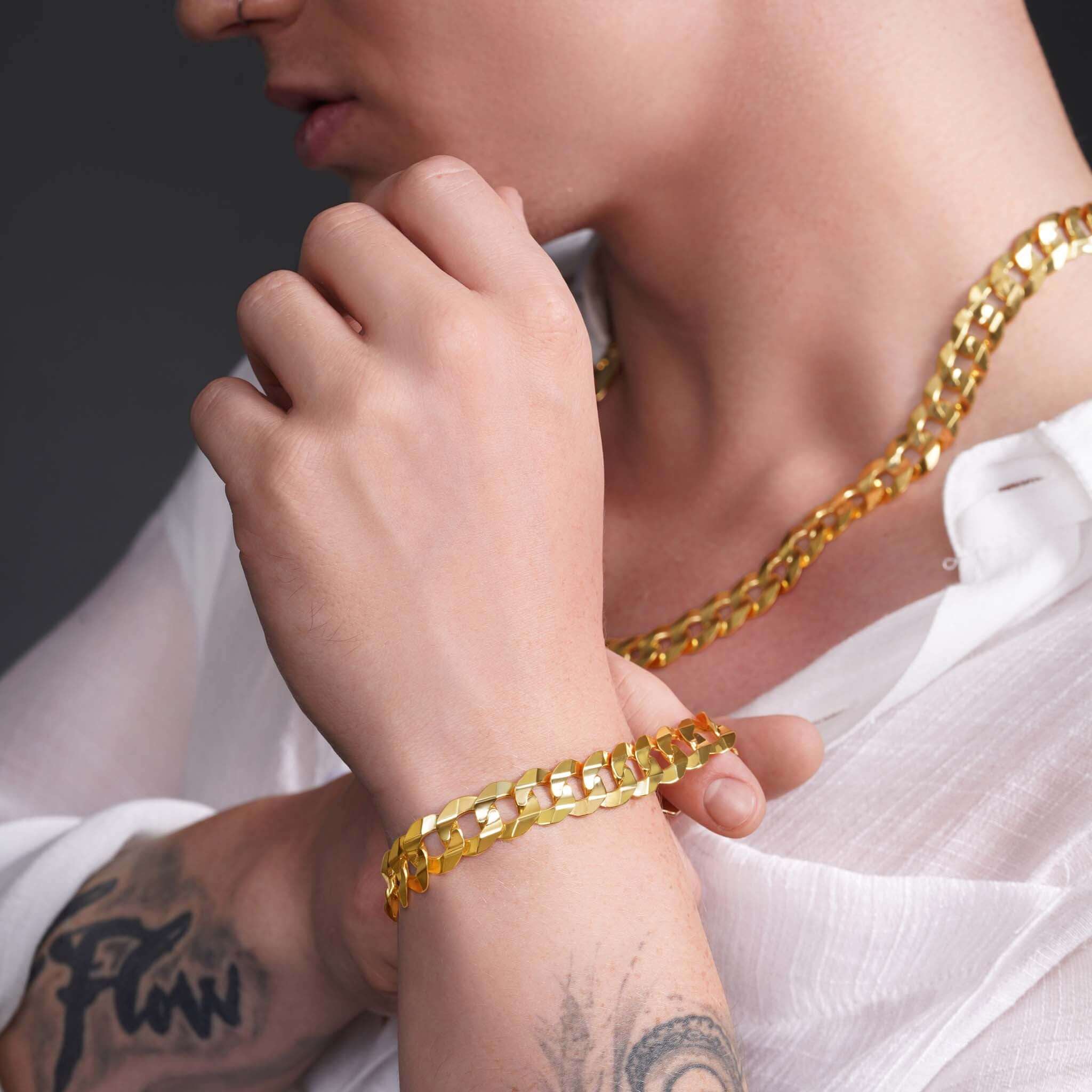 Men's 14K solid gold curb bracelet showcased alongside a matching necklace, highlighting luxury and style.