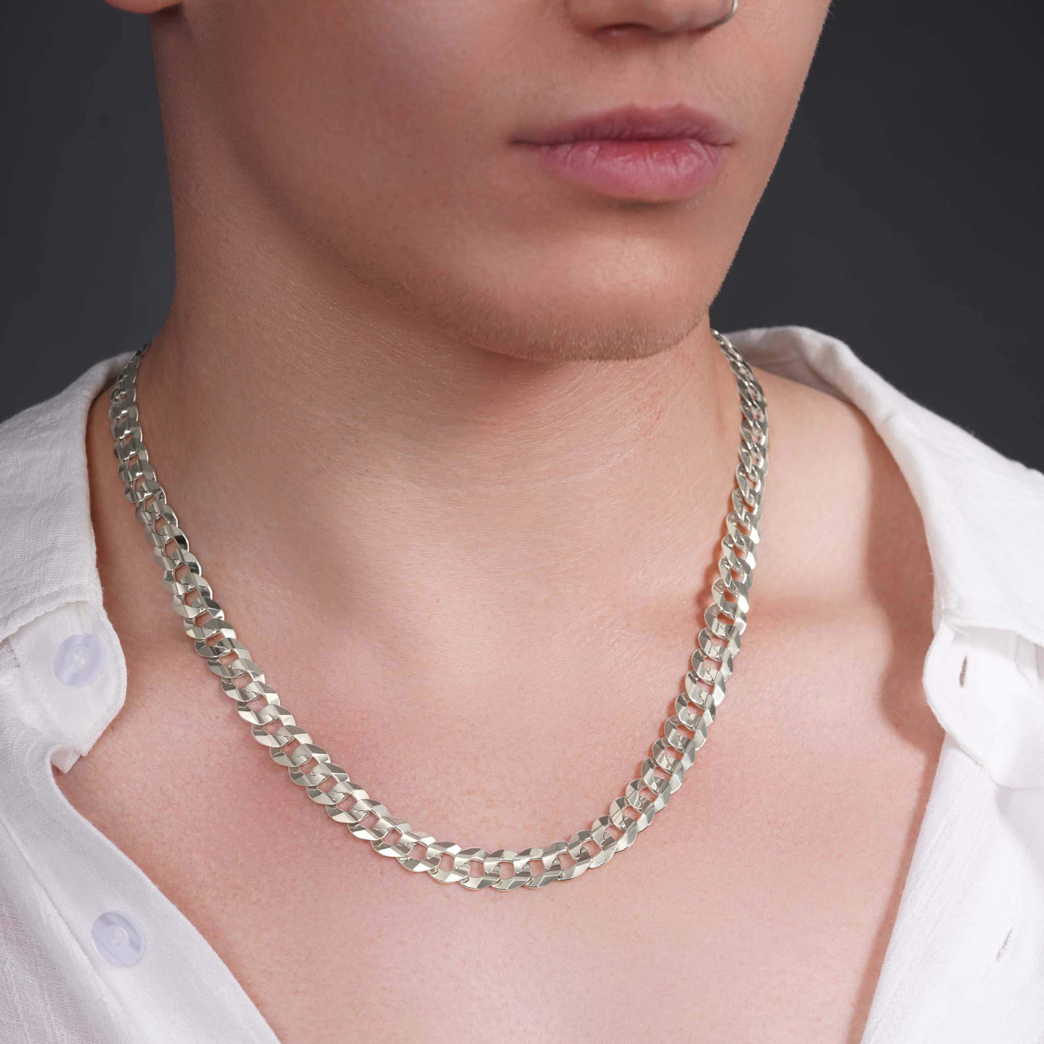 Close-up of a man wearing a stylish solid gold curb chain necklace, highlighting its polished links.