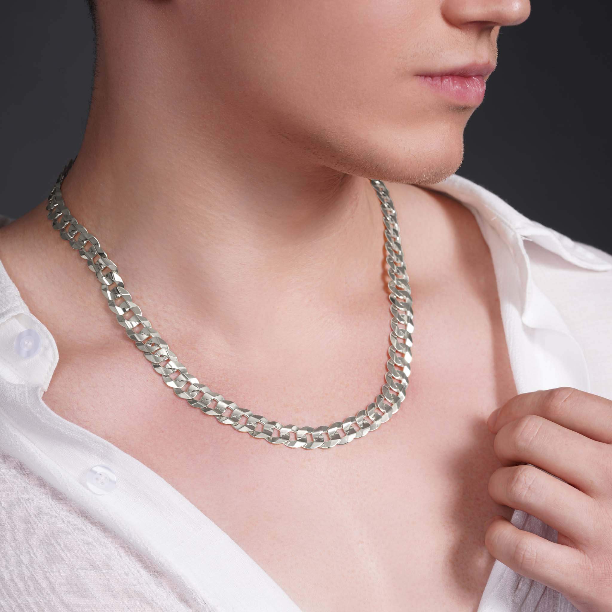 Men's solid gold curb chain necklace worn by a model, showcasing its sleek, interlocking design and luxurious shine.
