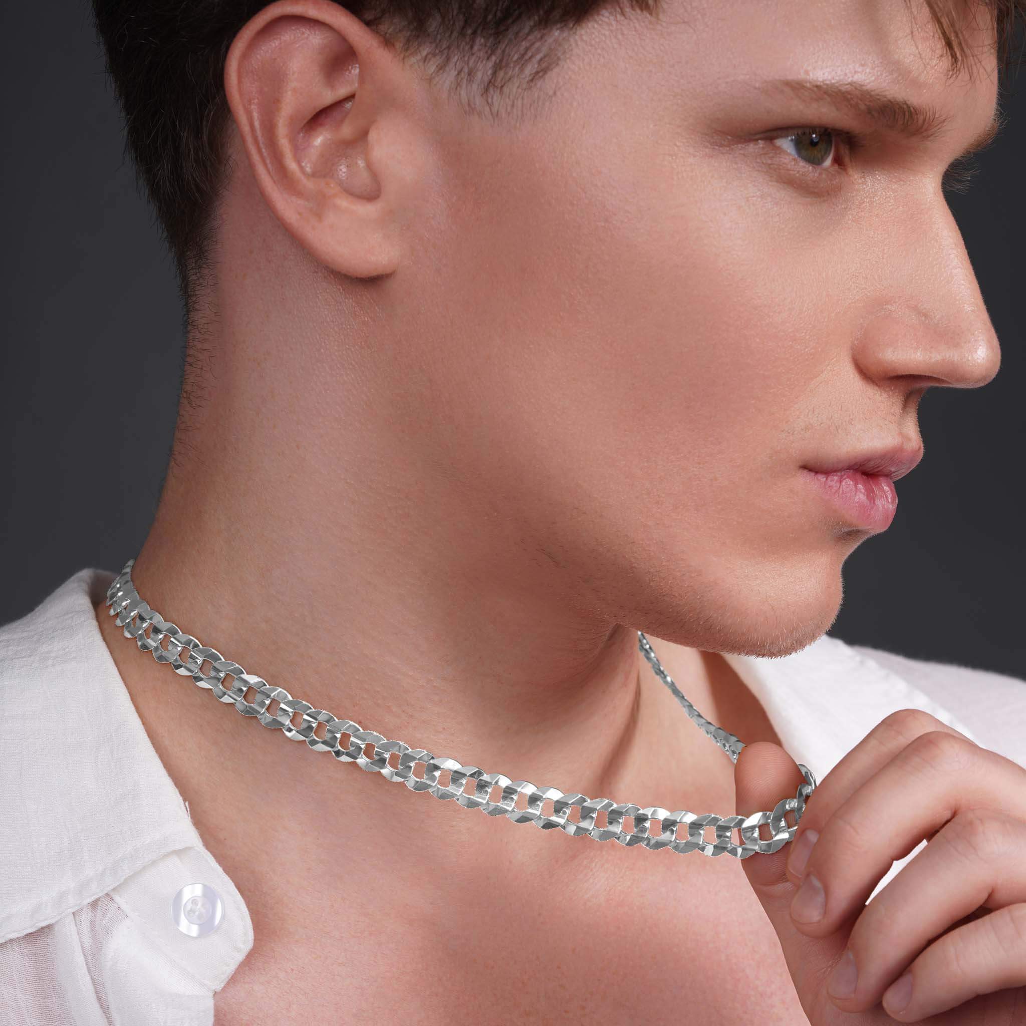 Stylish model showcasing a men's solid gold curb chain necklace in white gold against a dark background.