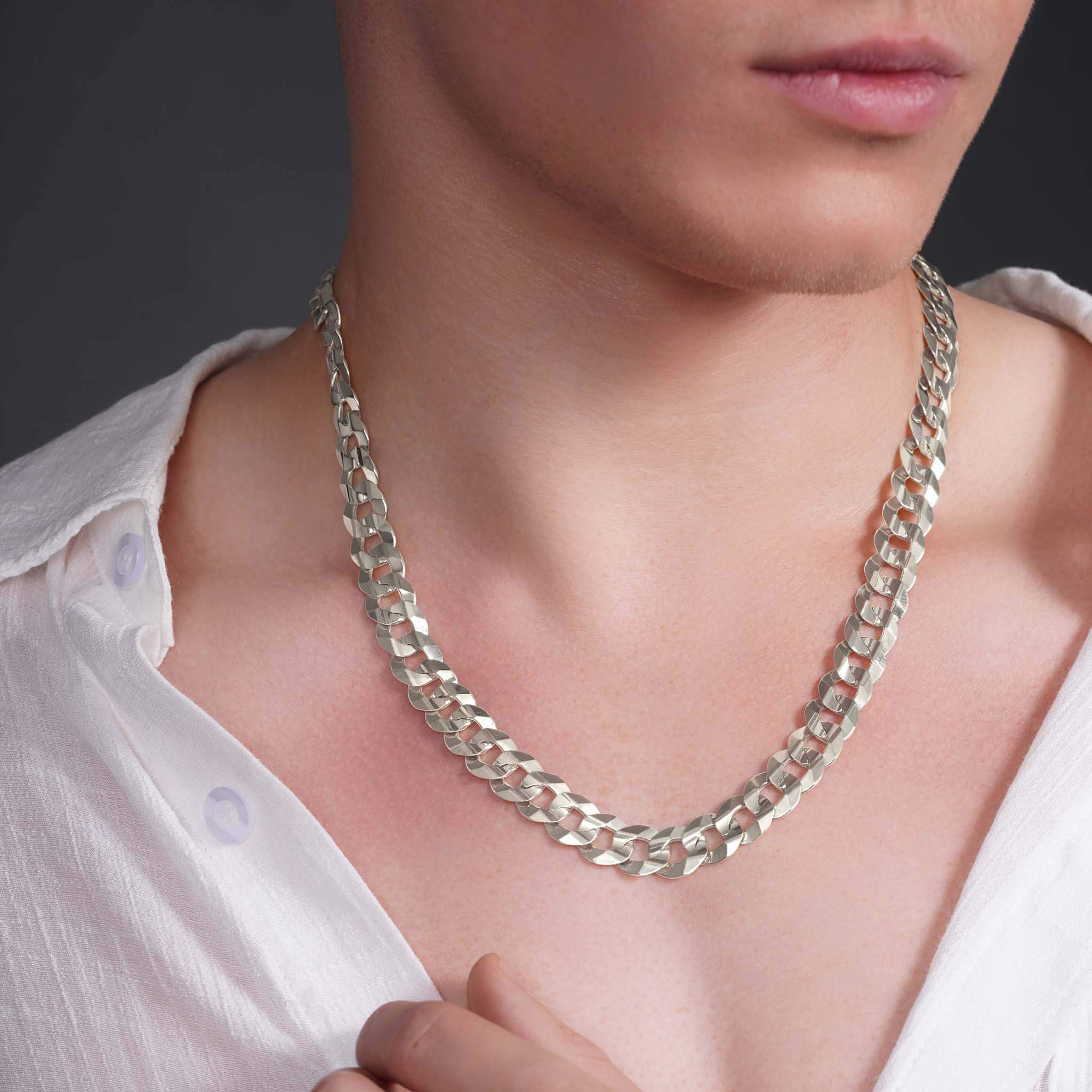 Men's solid gold curb chain worn by a model, showcasing its sleek design and interlocking links.