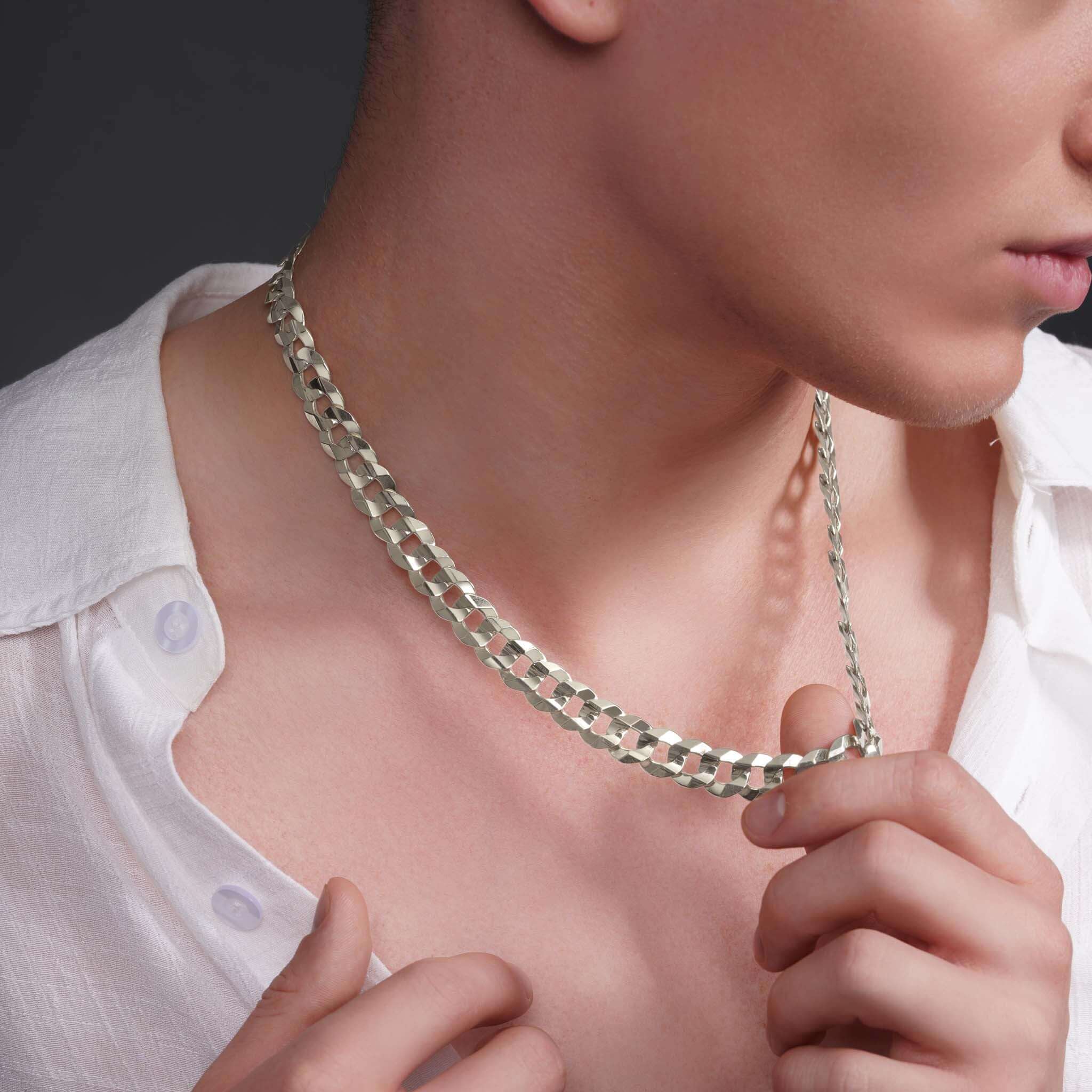 Close-up of a man wearing a sleek solid gold curb chain necklace, showcasing its elegance and shine.