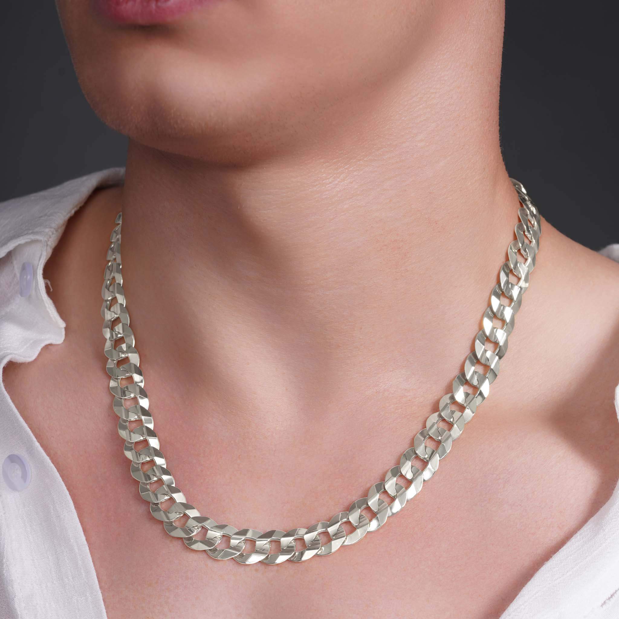 Men's solid gold curb chain necklace worn around the neck, showcasing its interlocking, flattened links.