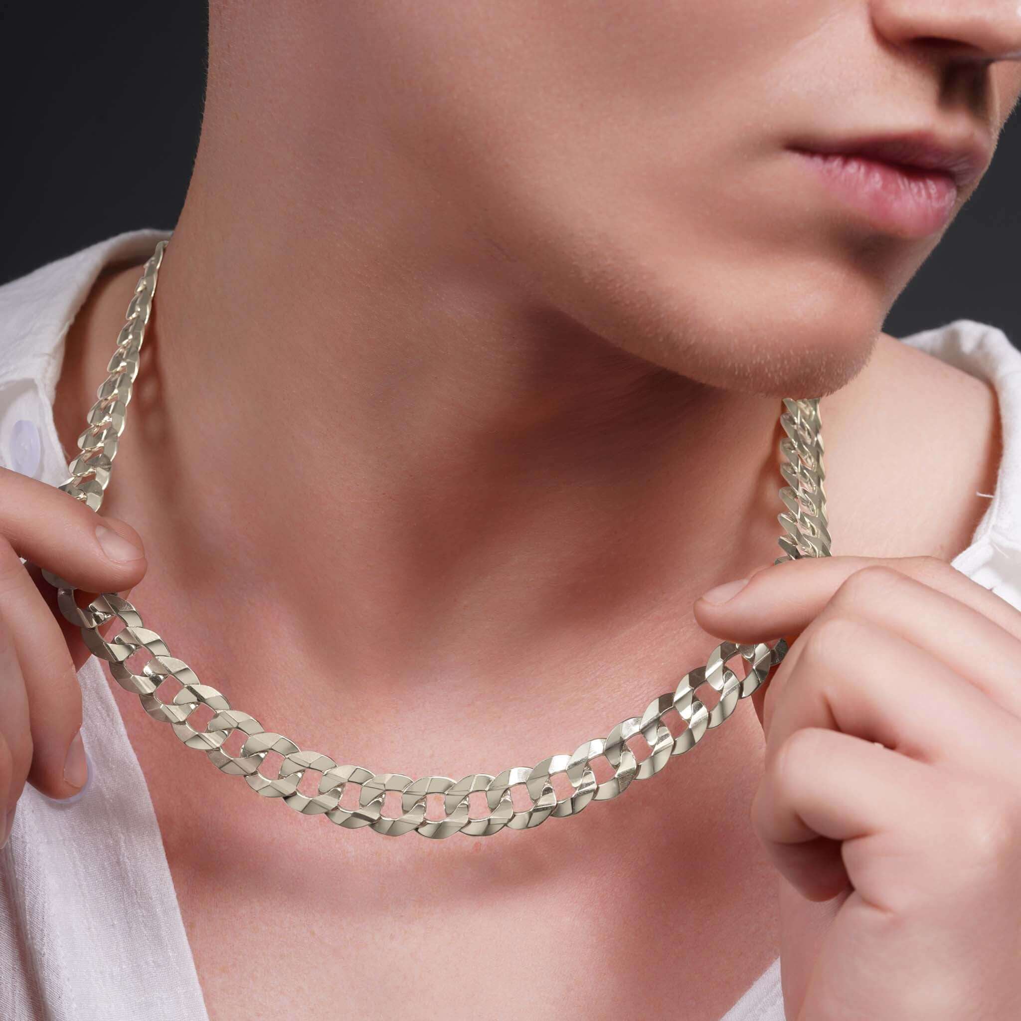 Men's solid gold curb chain draped around a man's neck, showcasing its smooth, interlocking design.