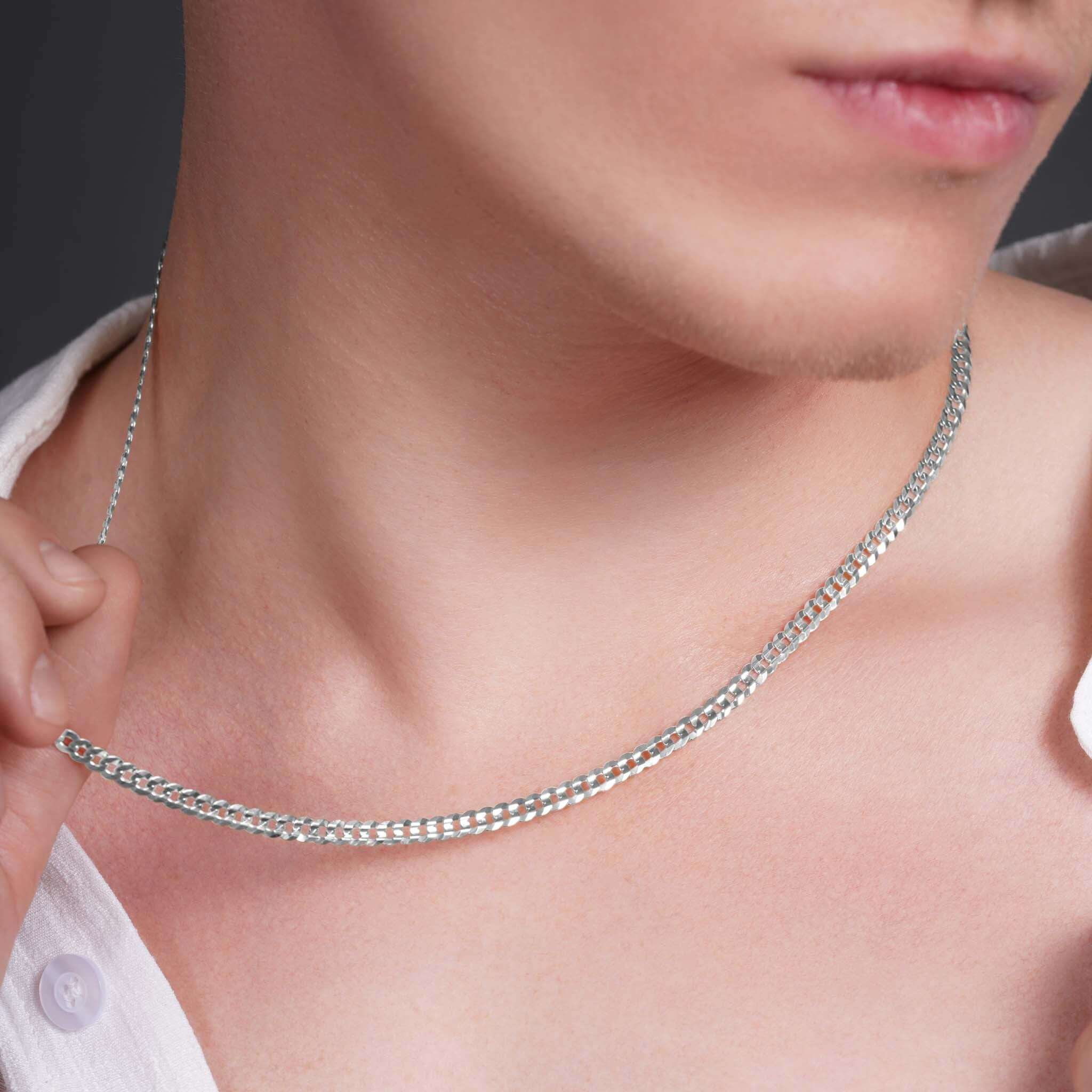 Close-up of a man wearing a 14k solid gold curb chain, showcasing its shine and elegant design.