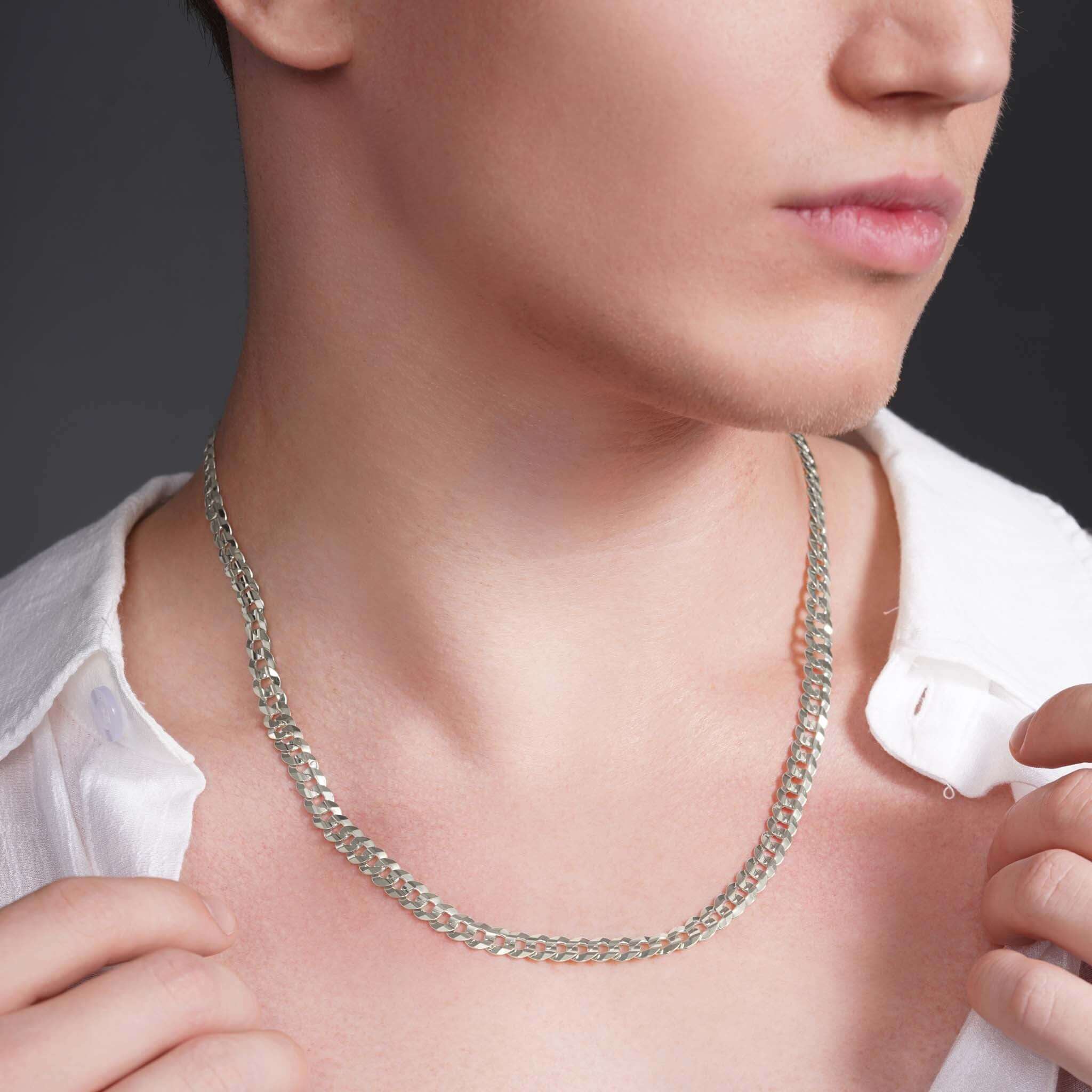 Men's solid gold curb chain worn by a model, showcasing its sleek design and premium craftsmanship.
