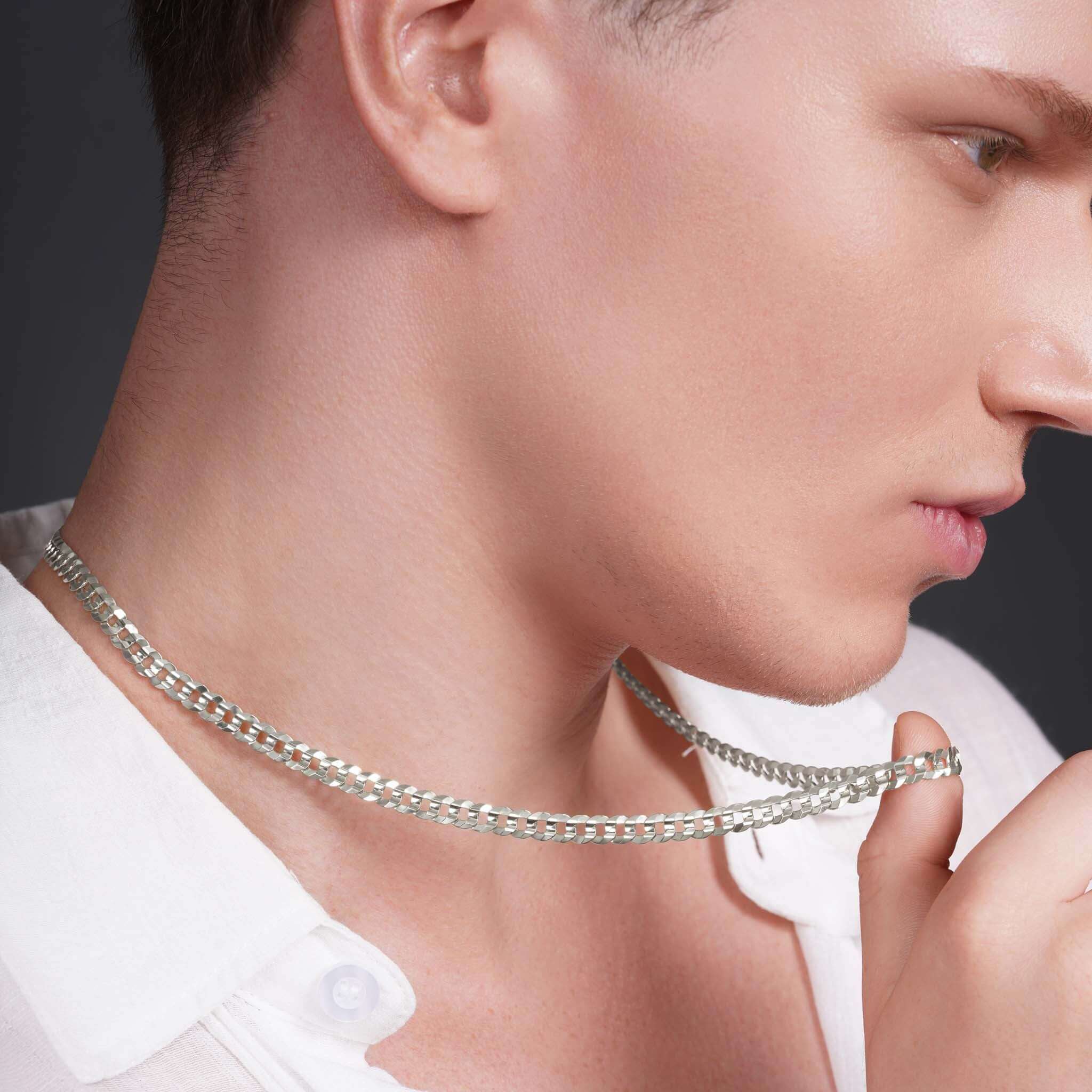 Close-up of a man wearing a Men's Solid Gold Curb Chain, showcasing its elegant design and shine.