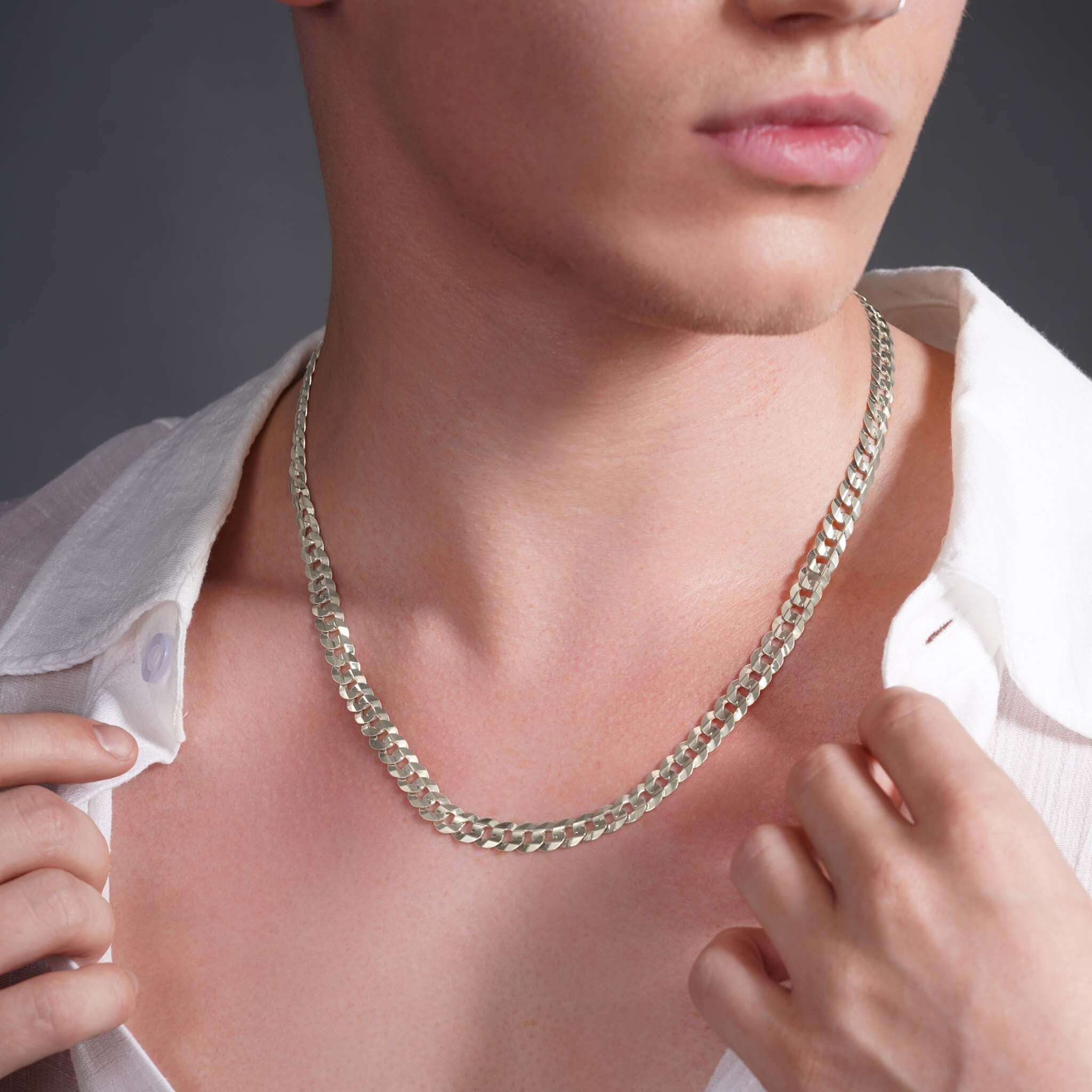 Close-up of a man wearing a solid gold curb chain necklace, showcasing style and elegance.