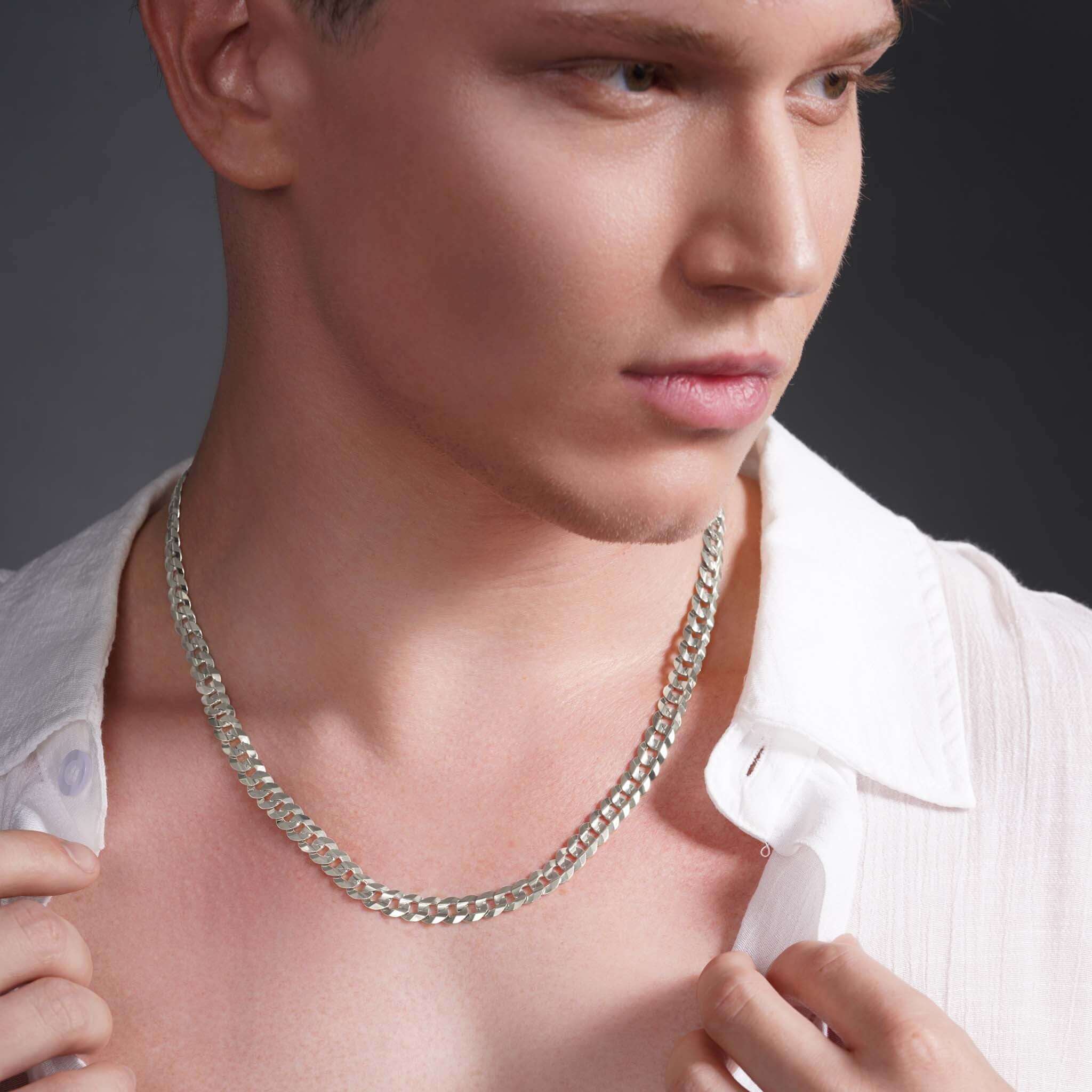 Close-up of a man wearing a sleek 14k solid gold curb chain necklace, showcasing its elegant design and shine.