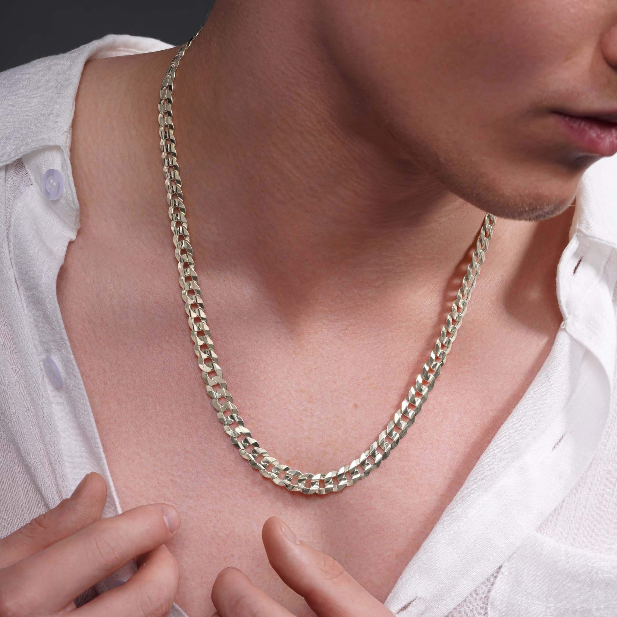Men's solid gold curb chain resting on a man's neck, showcasing its sleek, interlocking links and shine.