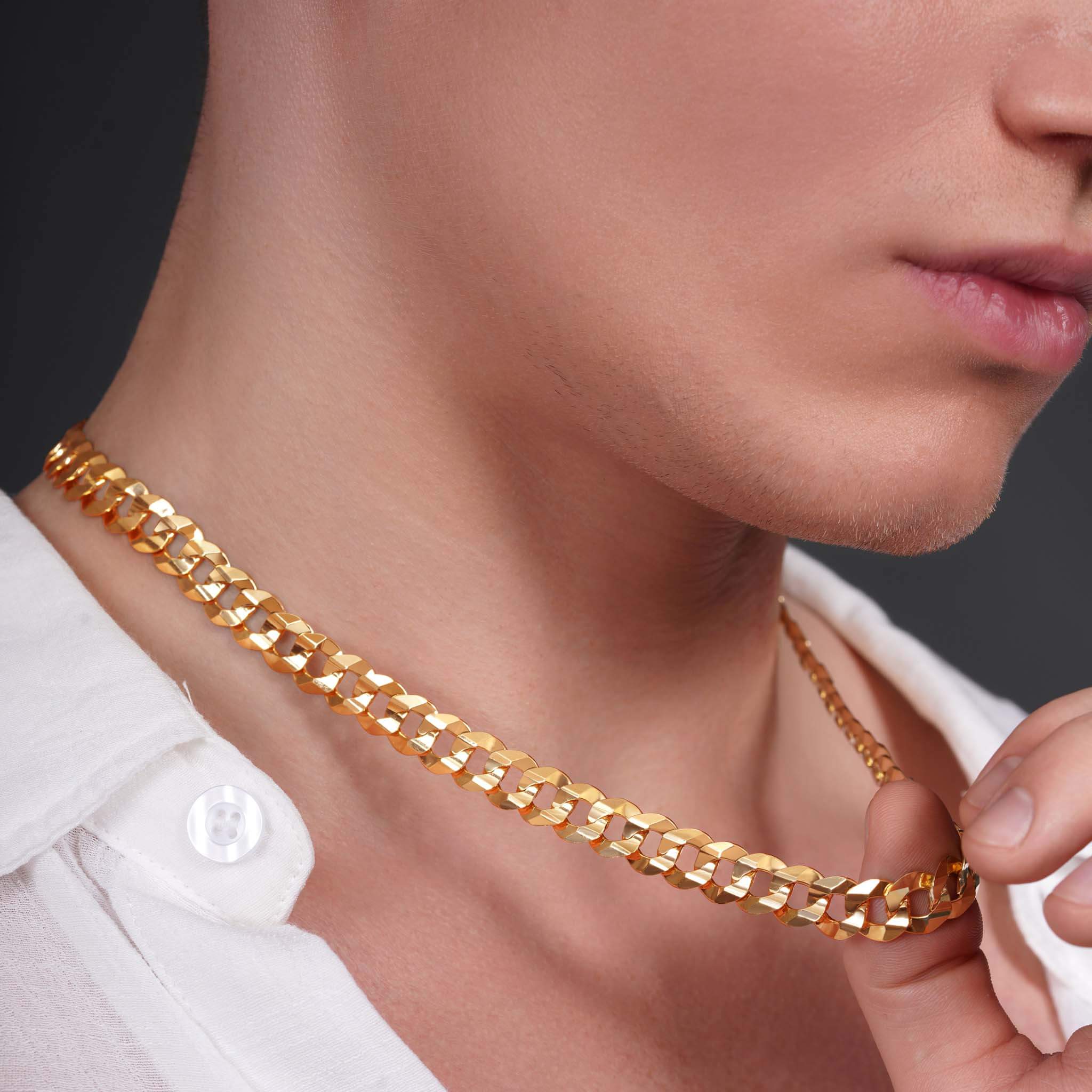 Close-up of a man wearing a Men’s Solid Gold Curb Chain, showcasing its luxurious design and shine.