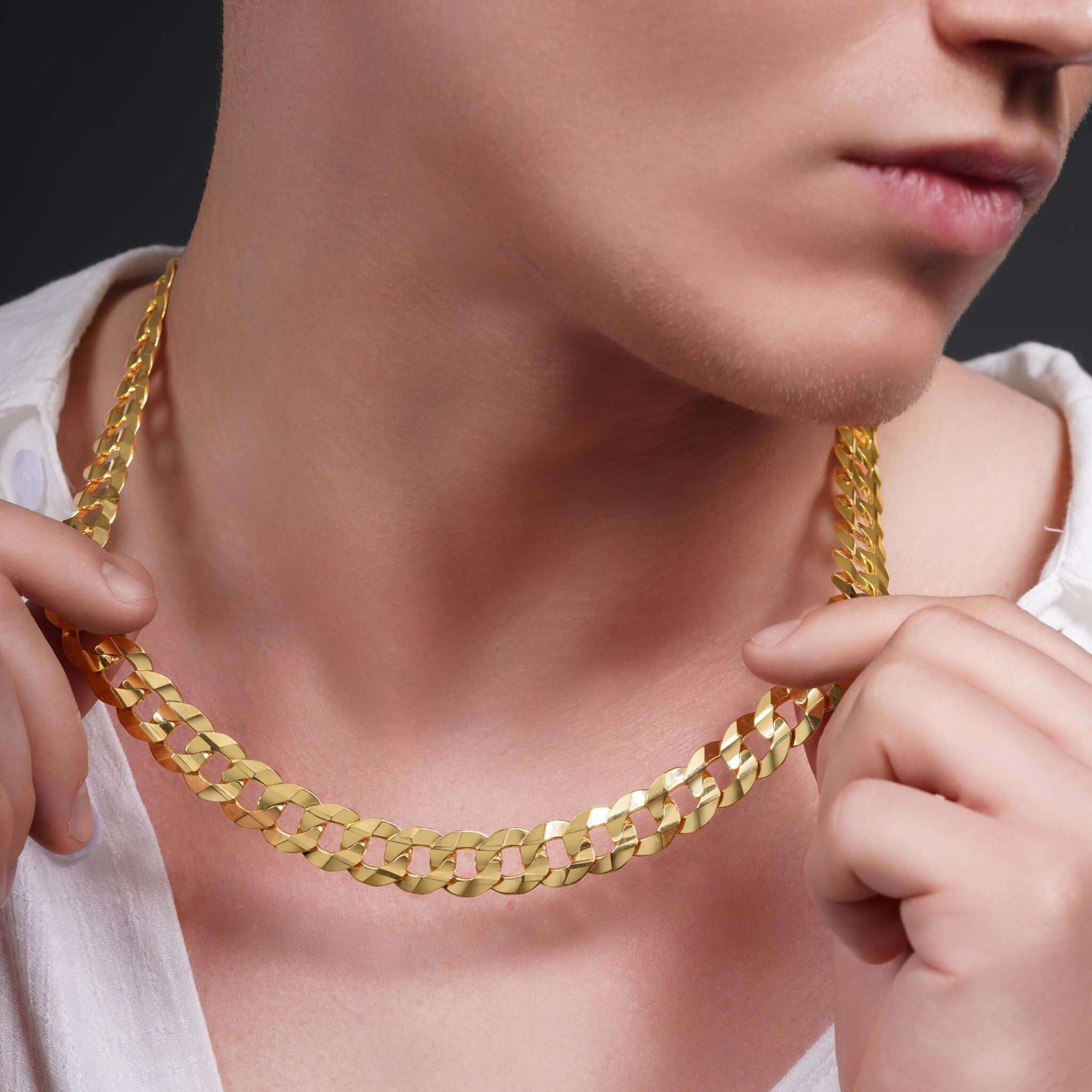 Men's solid gold curb chain necklace worn by a model, showcasing its luxurious design and shiny finish.