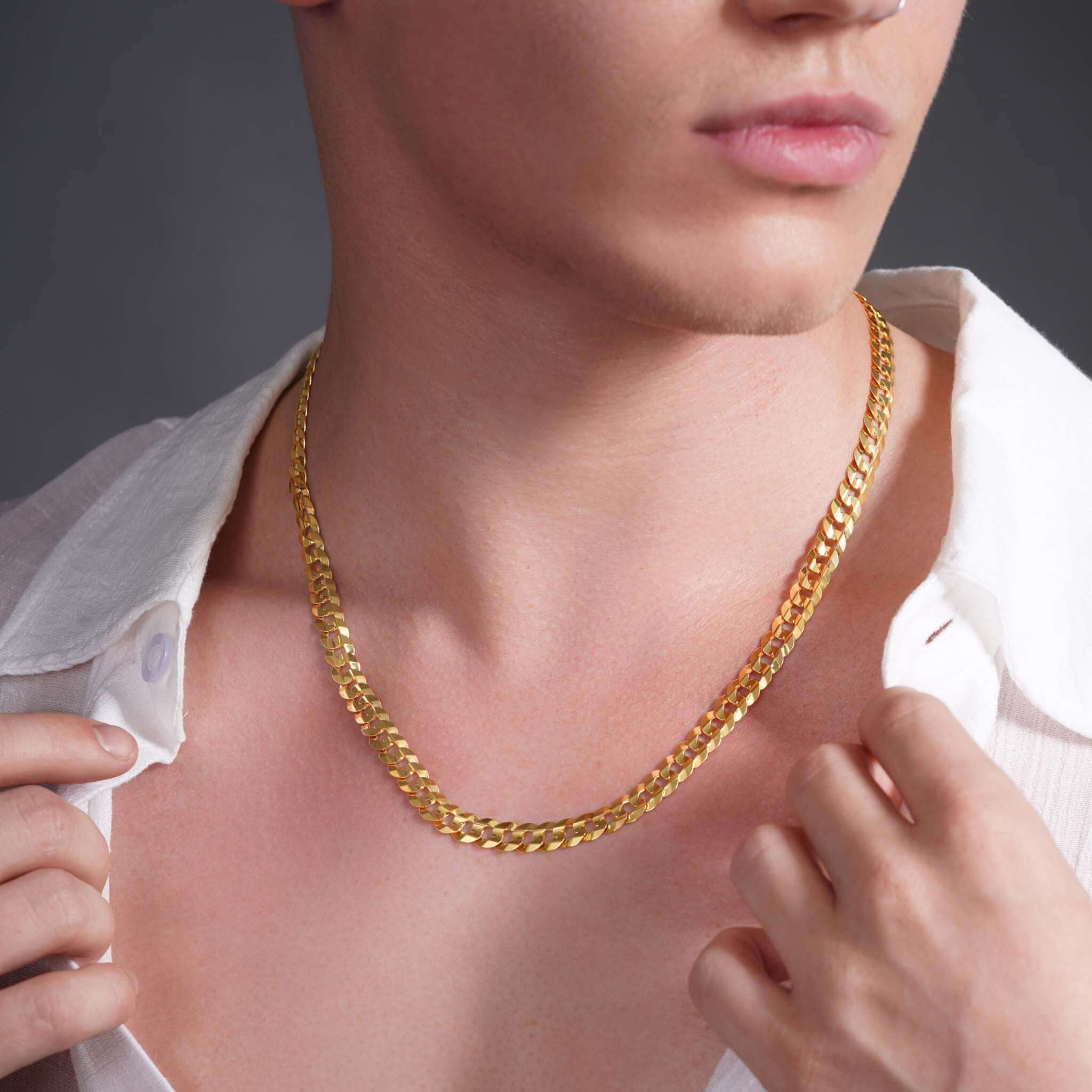 Men's solid gold curb chain worn on a model, showcasing its sleek design and luxurious shine.