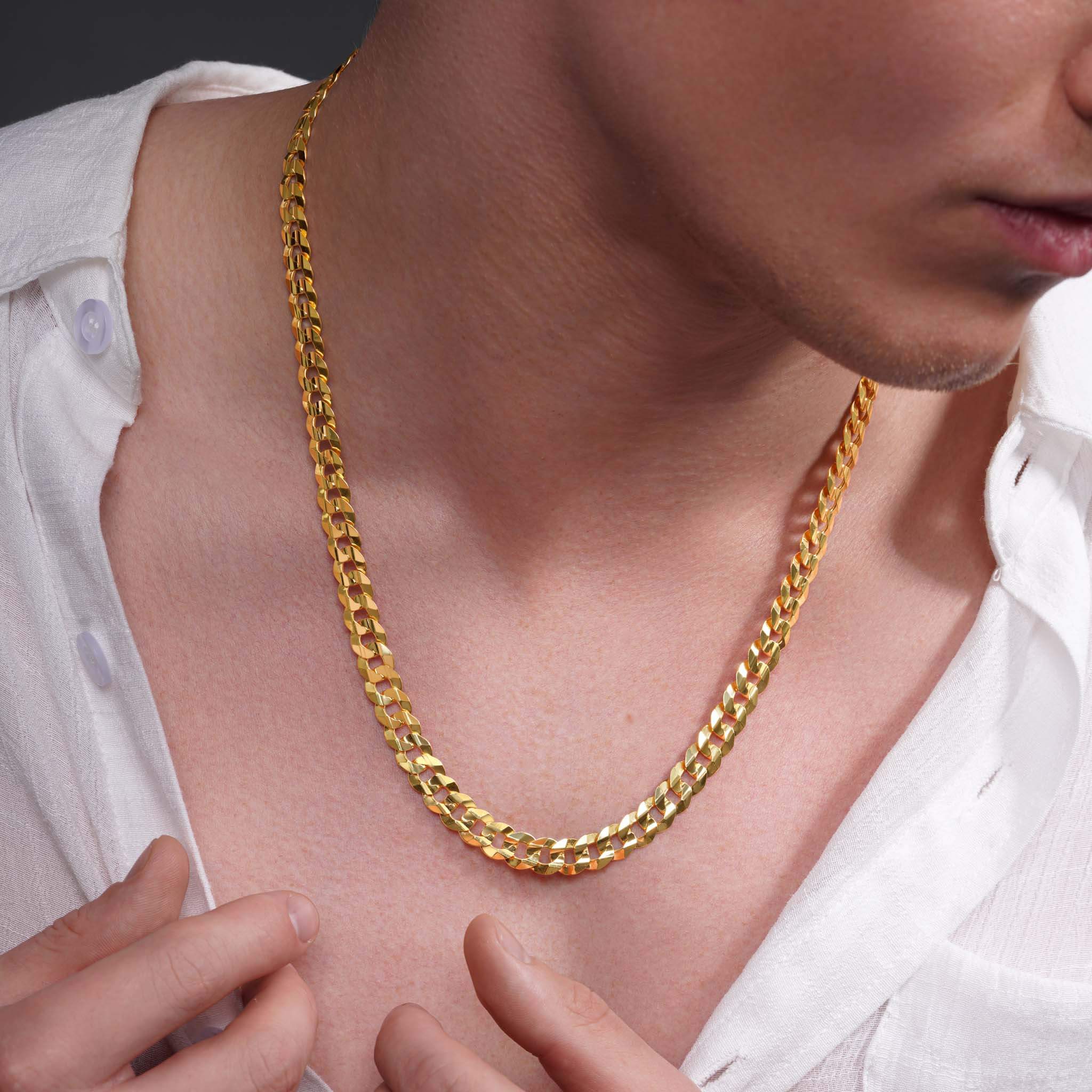 Men's solid gold curb chain worn around the neck, showcasing its elegant shine and classic design.