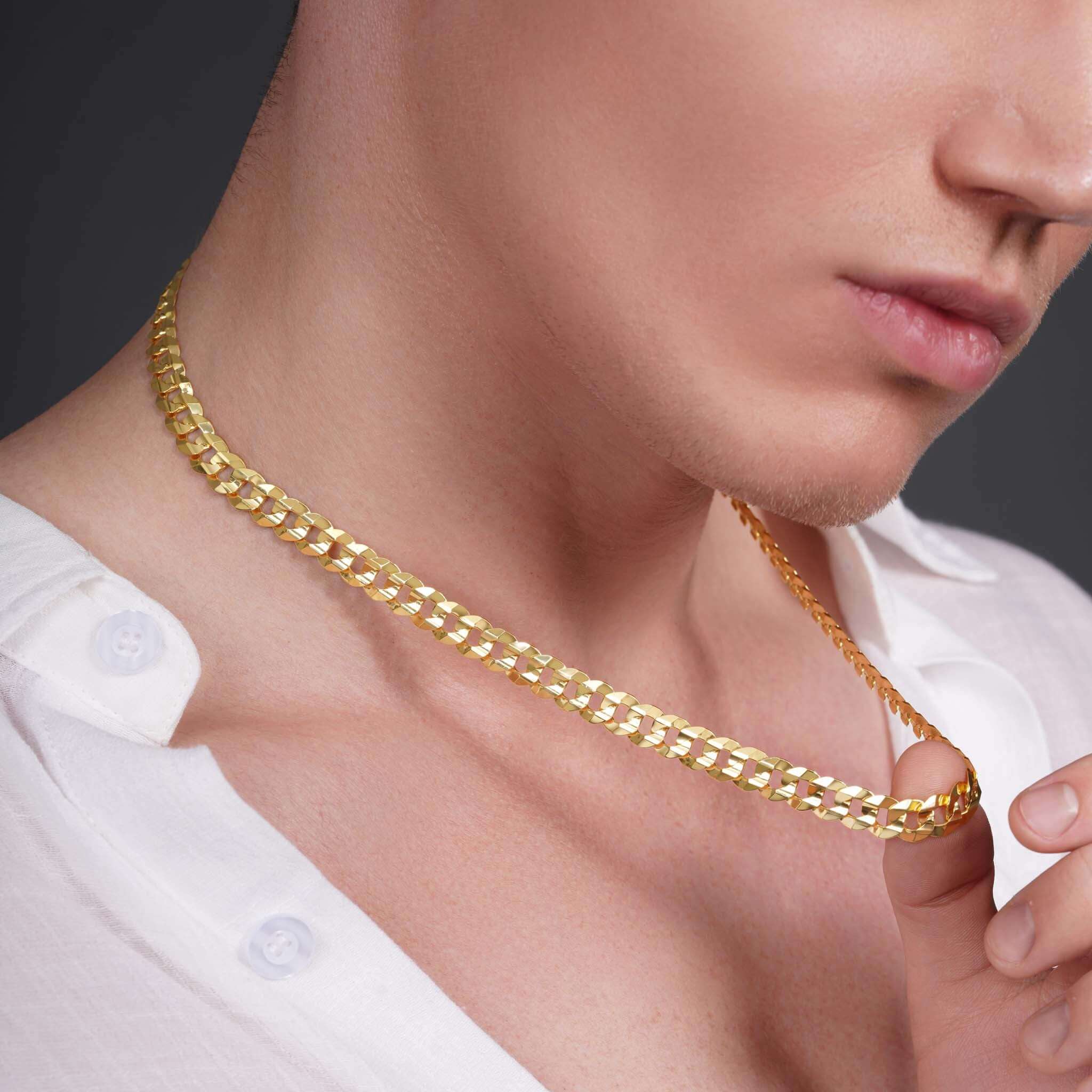 Men's solid gold curb chain worn by a model, showcasing its stylish design and shine.