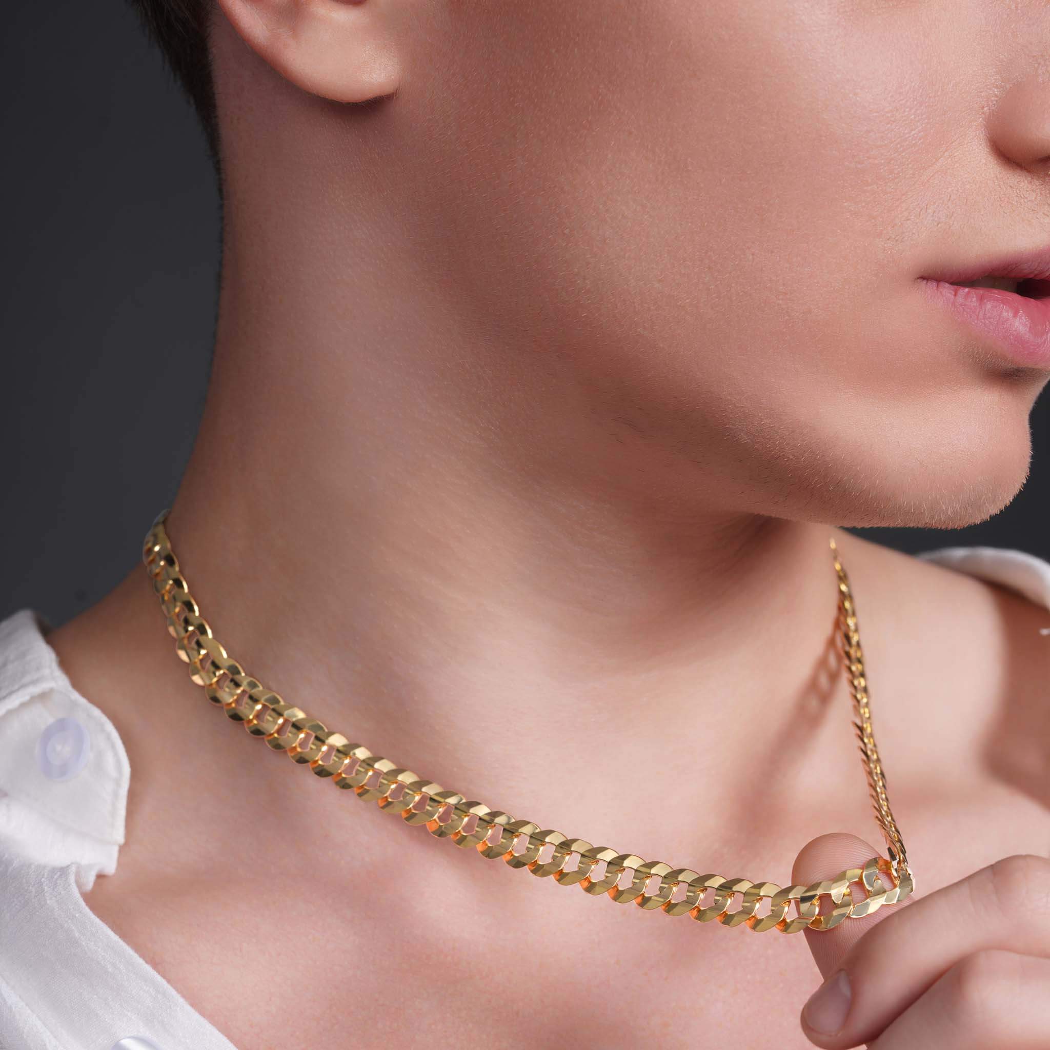 Close-up of a male model wearing a men's solid gold curb chain necklace, showcasing its shine and elegant design.
