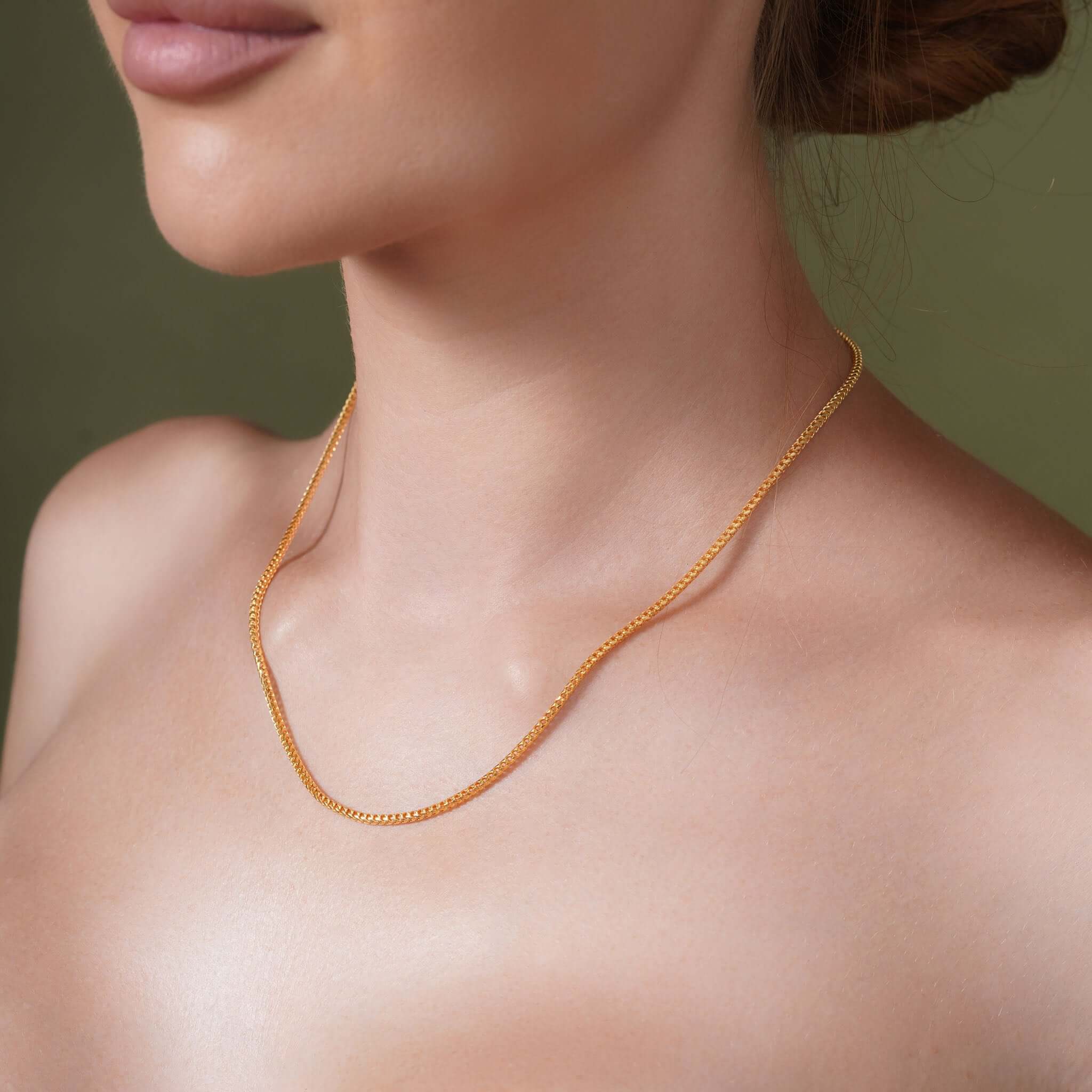 Woman wearing a Diamond Cut Franco Chain in 14k solid yellow gold, highlighting its shining facets.