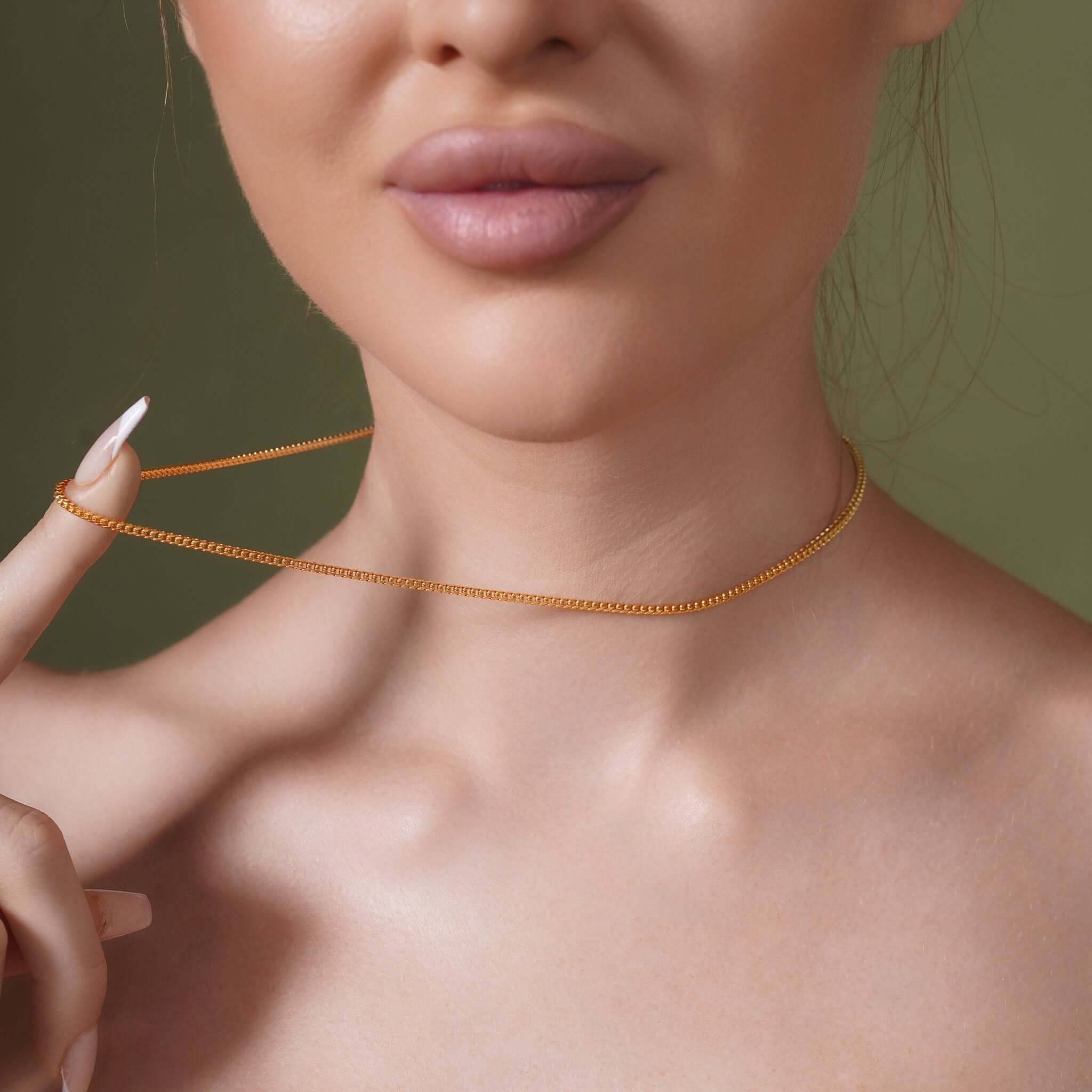 Model showcasing a Diamond Cut Franco Chain around her neck against a soft green background.