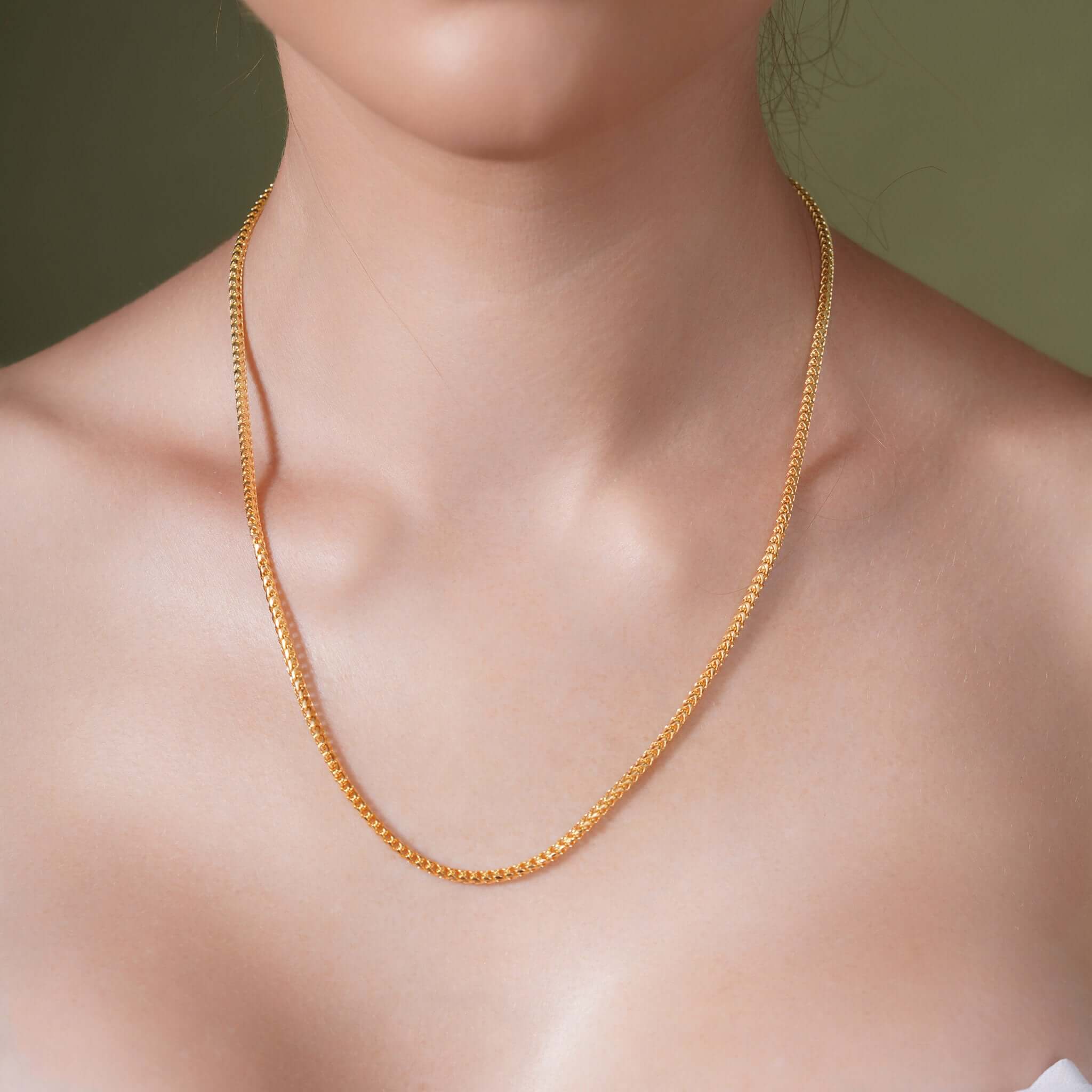 Model showcasing the Diamond Cut Franco Chain in 14k solid yellow gold, highlighting its shimmering design.