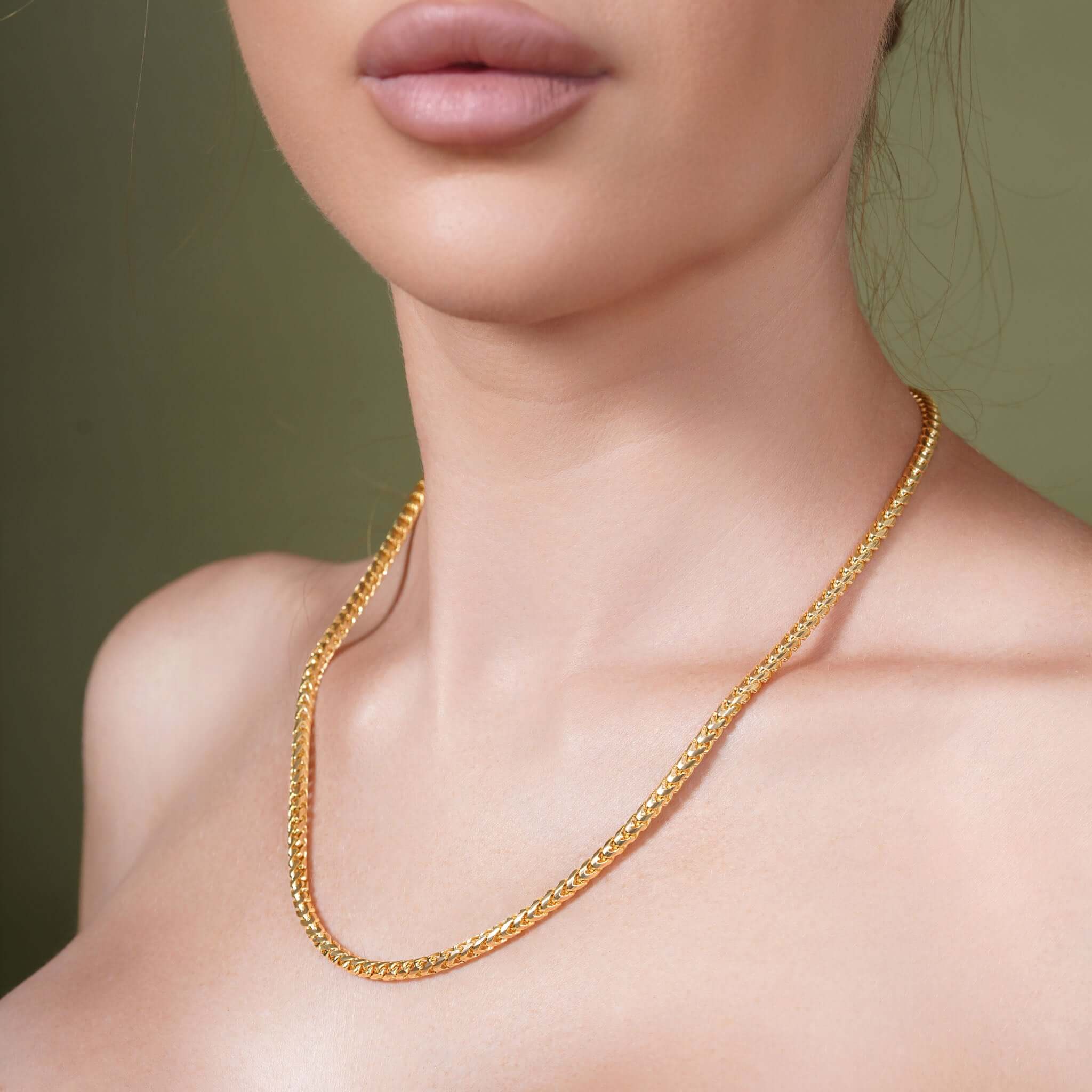Close-up of a woman wearing a Diamond Cut Franco Chain in solid yellow gold.