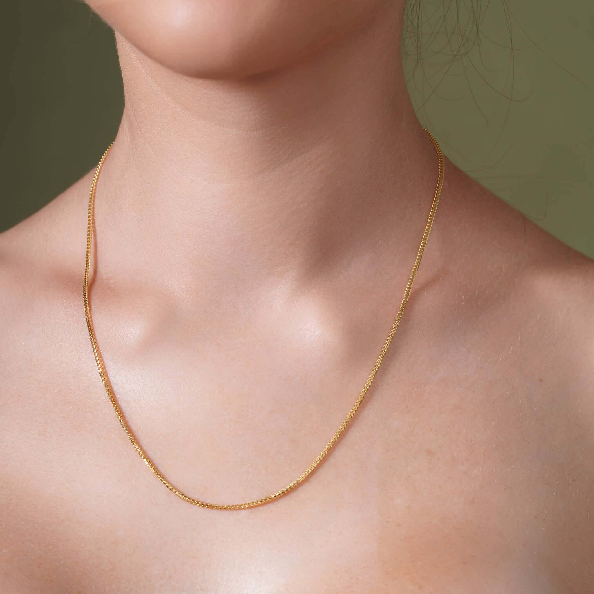 Franco Gold Chain displayed on a model, showcasing its sleek design in solid yellow gold.