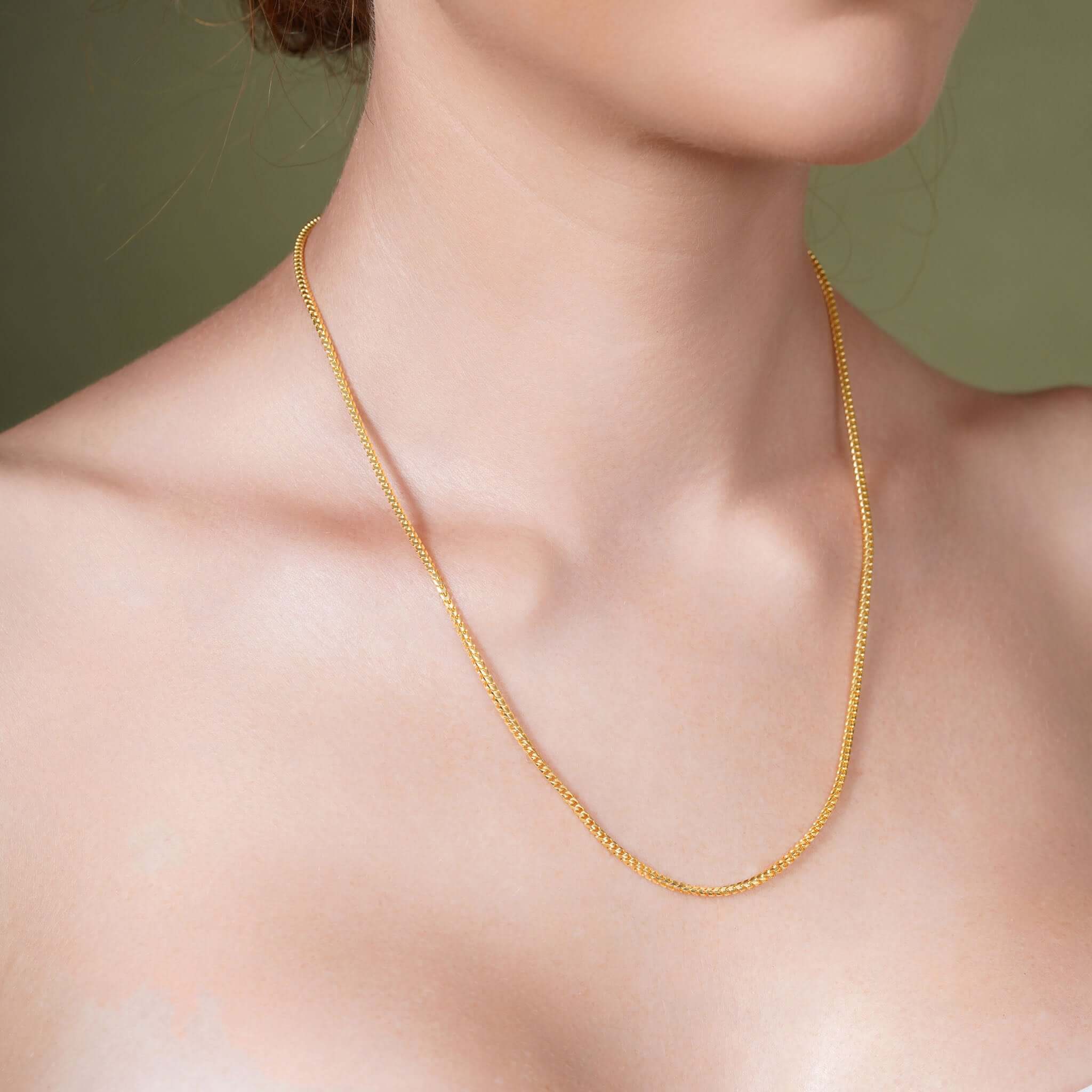 Franco Gold Chain on a model, showcasing 14k solid gold with a sleek, flat design.