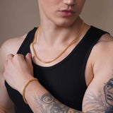 Men's Diamond Cut Franco Gold Chain worn by a man with tattoos, showcasing its sleek and sophisticated design.