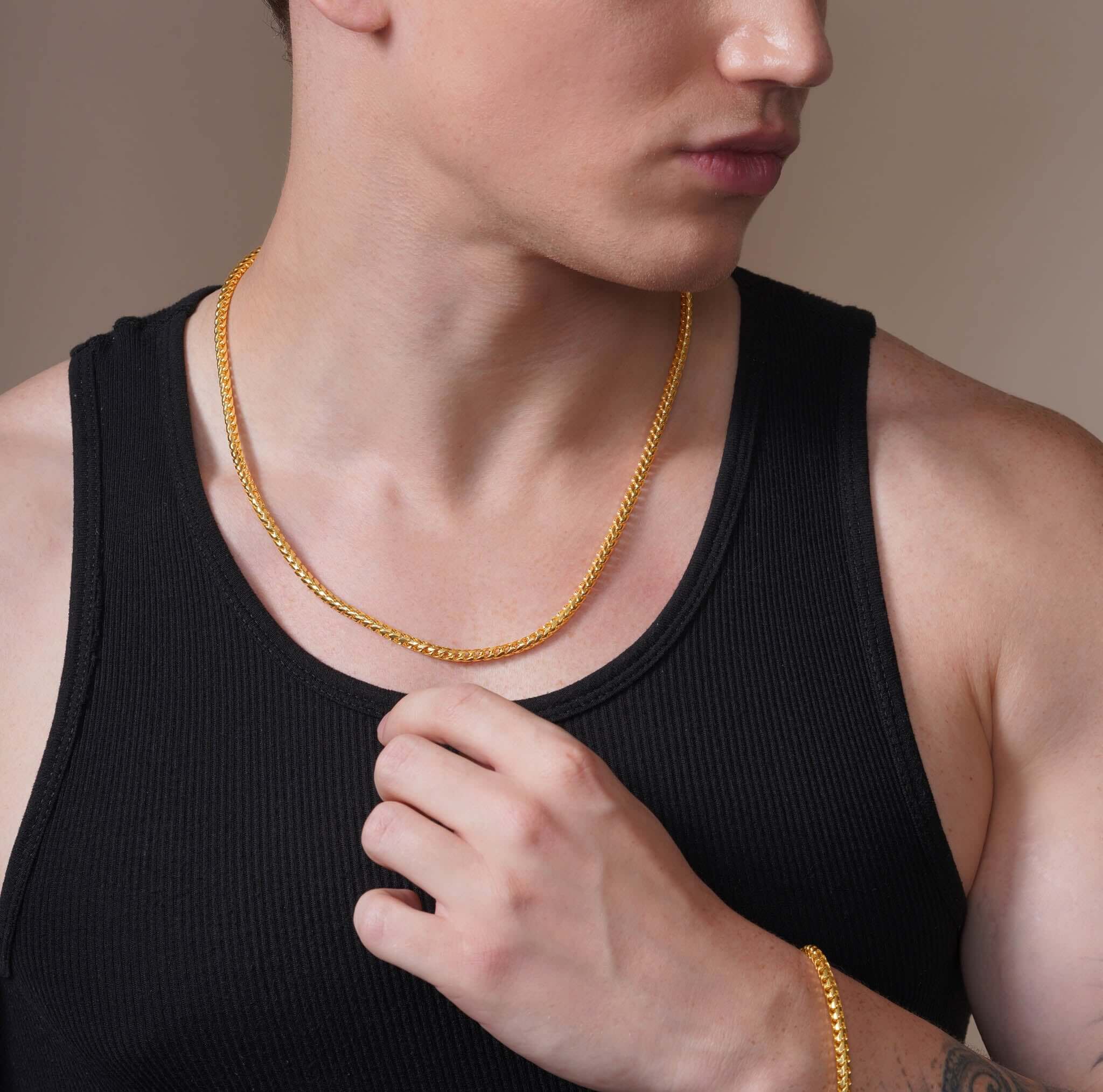 Man wearing Men's Diamond Cut Franco Gold Chain, showcasing its elegance and shine against a black tank top.