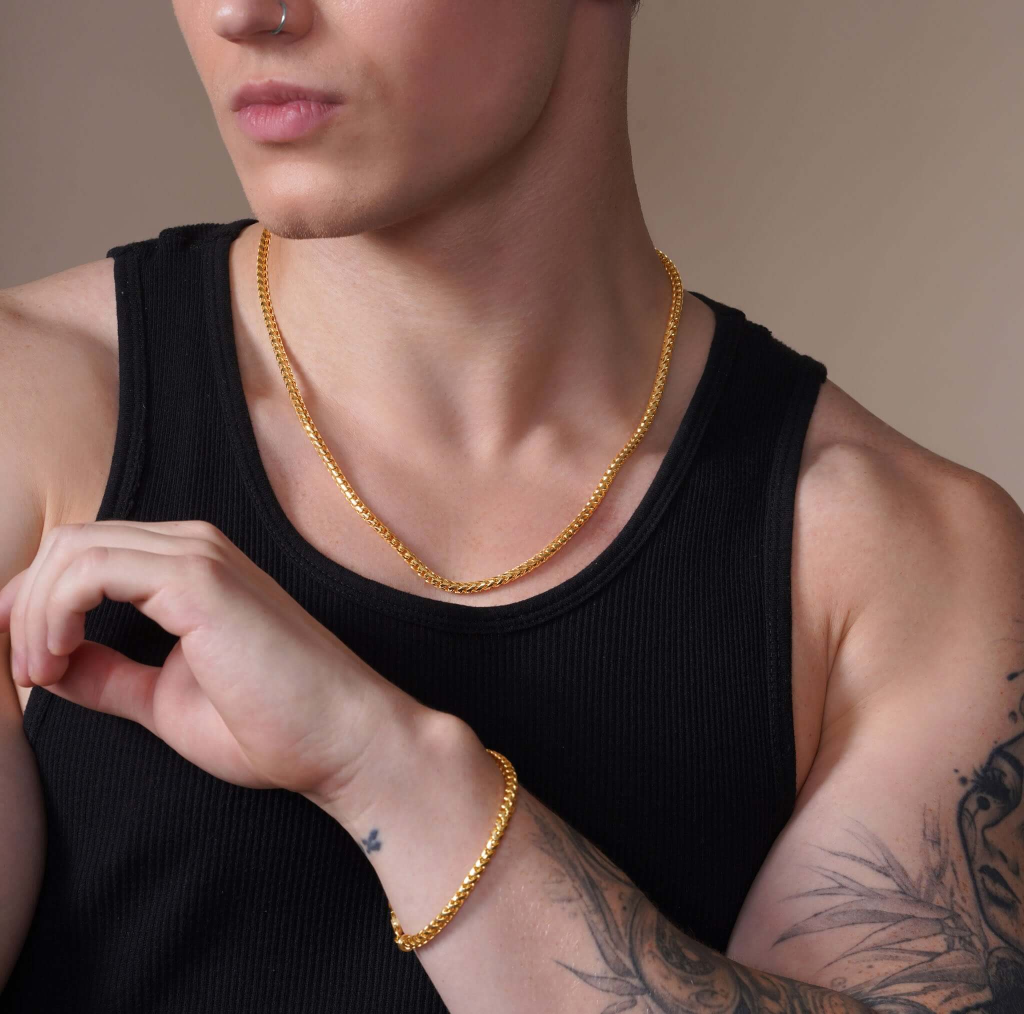 Men's Diamond Cut Franco Gold Chain worn by a man showcasing its brilliance and style with a matching bracelet.