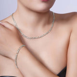 Woman wearing a fashionable Figaro Gold Chain necklace and bracelet in 14k white gold.