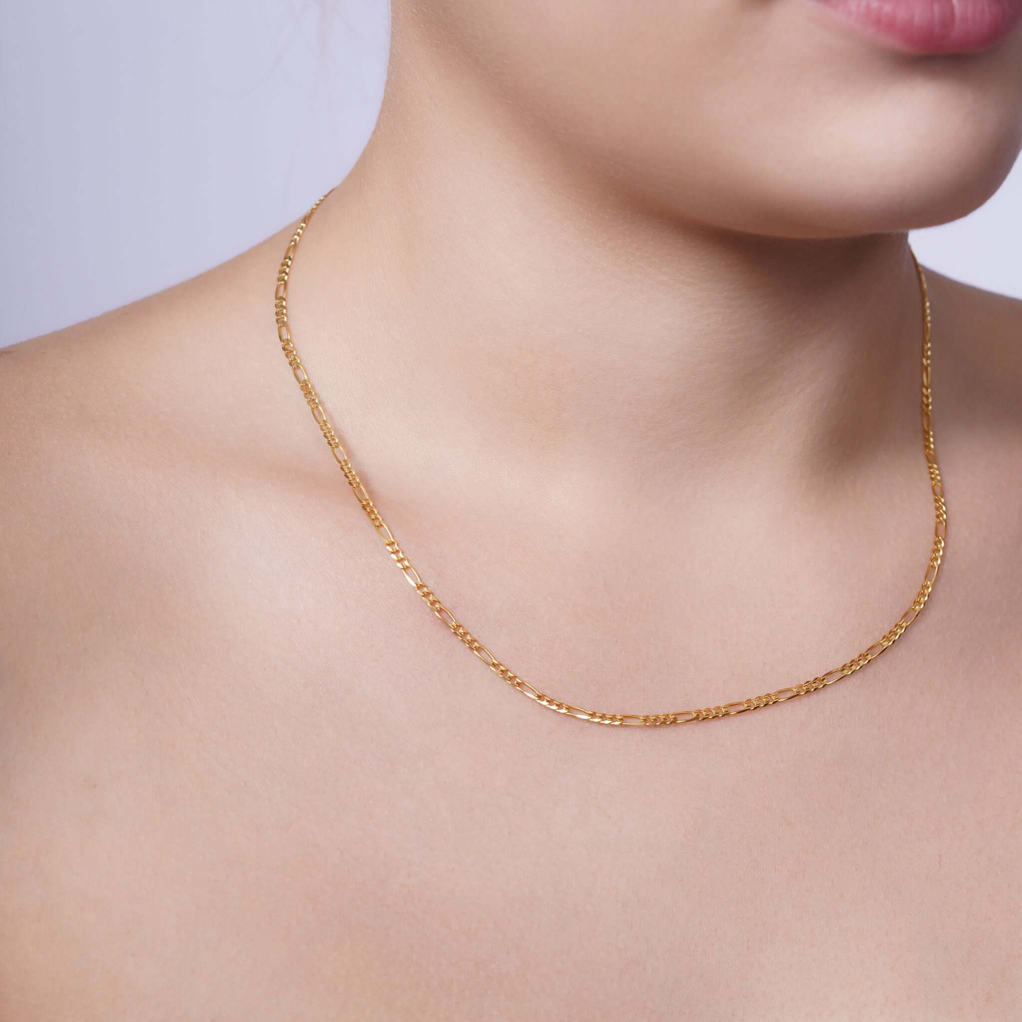 Figaro Gold Chain displayed elegantly on a woman's neck, showcasing its timeless design and quality craftsmanship.