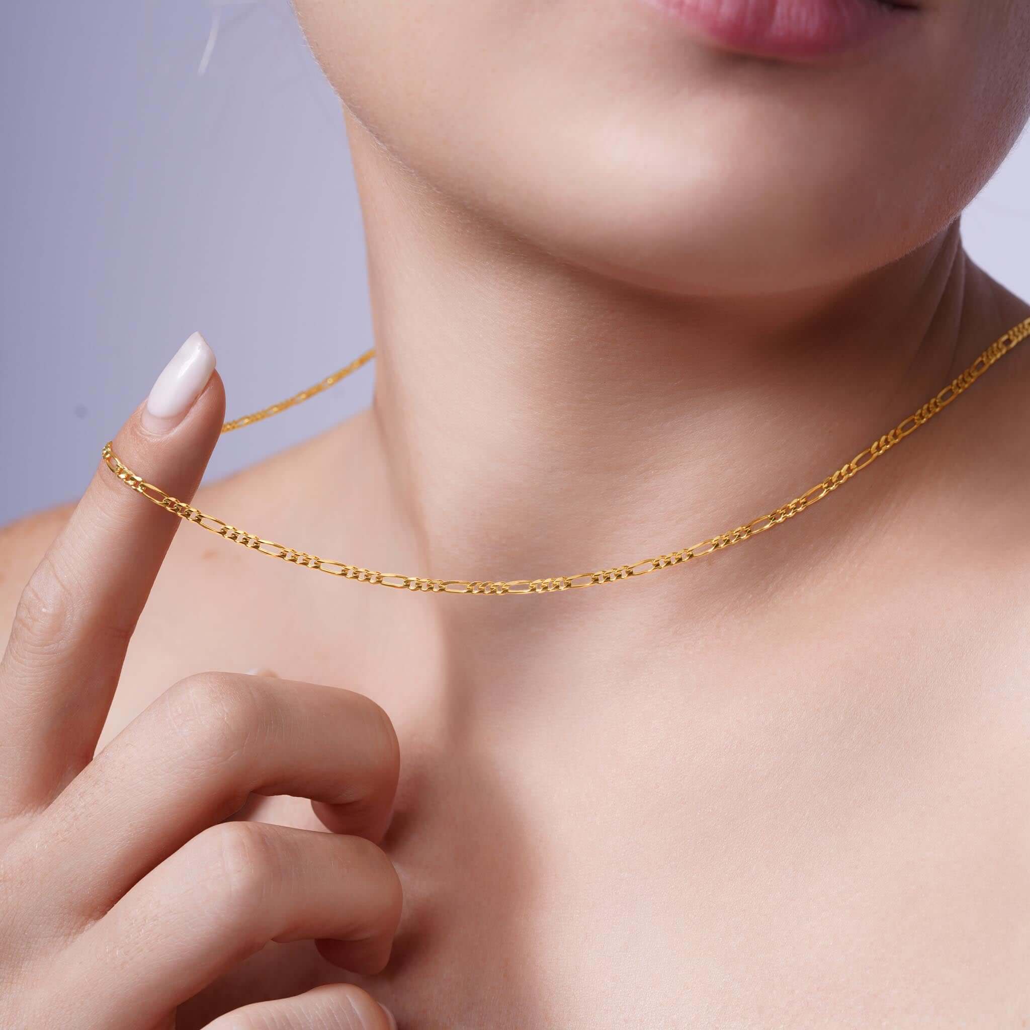 Close-up of a woman wearing a Figaro Gold Chain, showcasing its elegant design and sophistication.