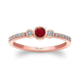 Mia Ruby three stone diamond promise ring featuring a ruby center and two bezel set diamonds, set in rose gold.