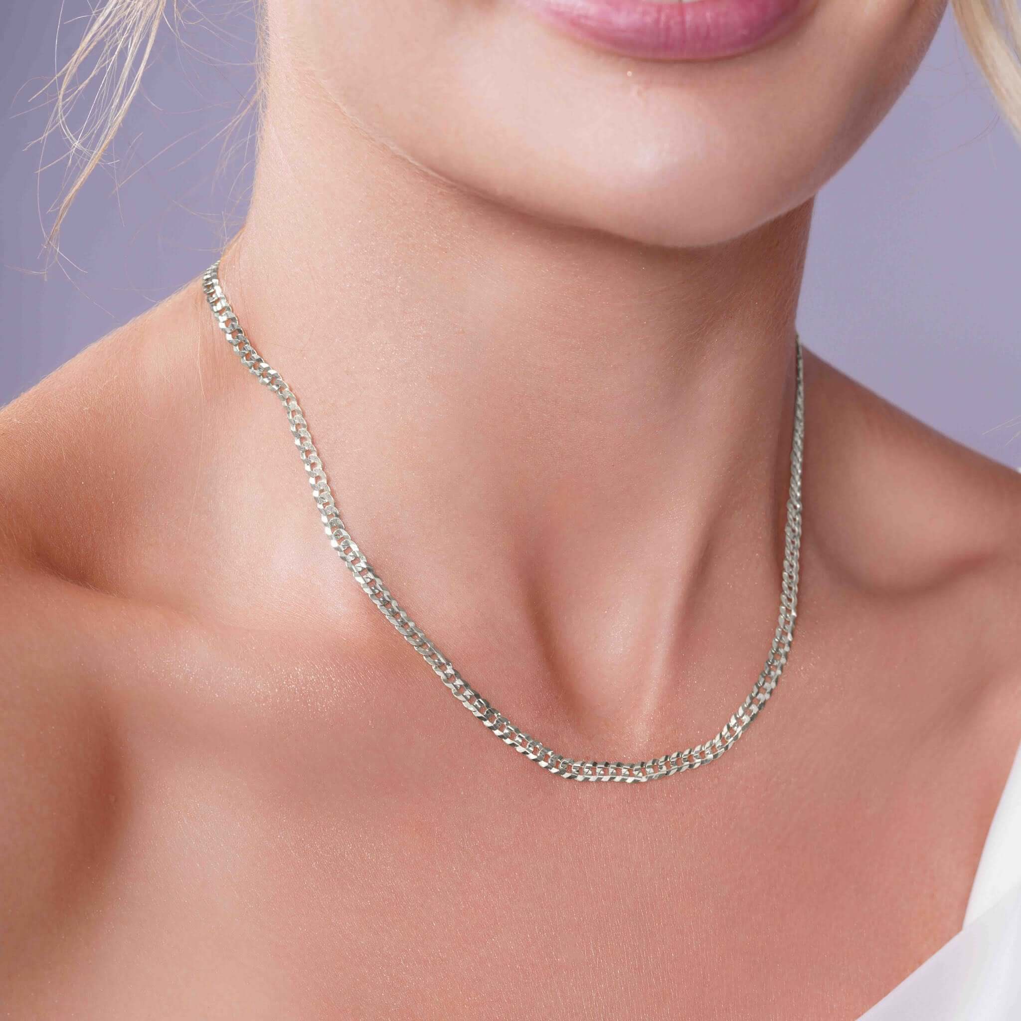 Curb Silver Chain elegantly worn by a woman, showcasing its sophisticated design and durable silver links.