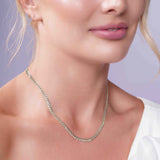Curb Silver Chain worn by a woman, showcasing its elegant design and durable silver links against her neckline.