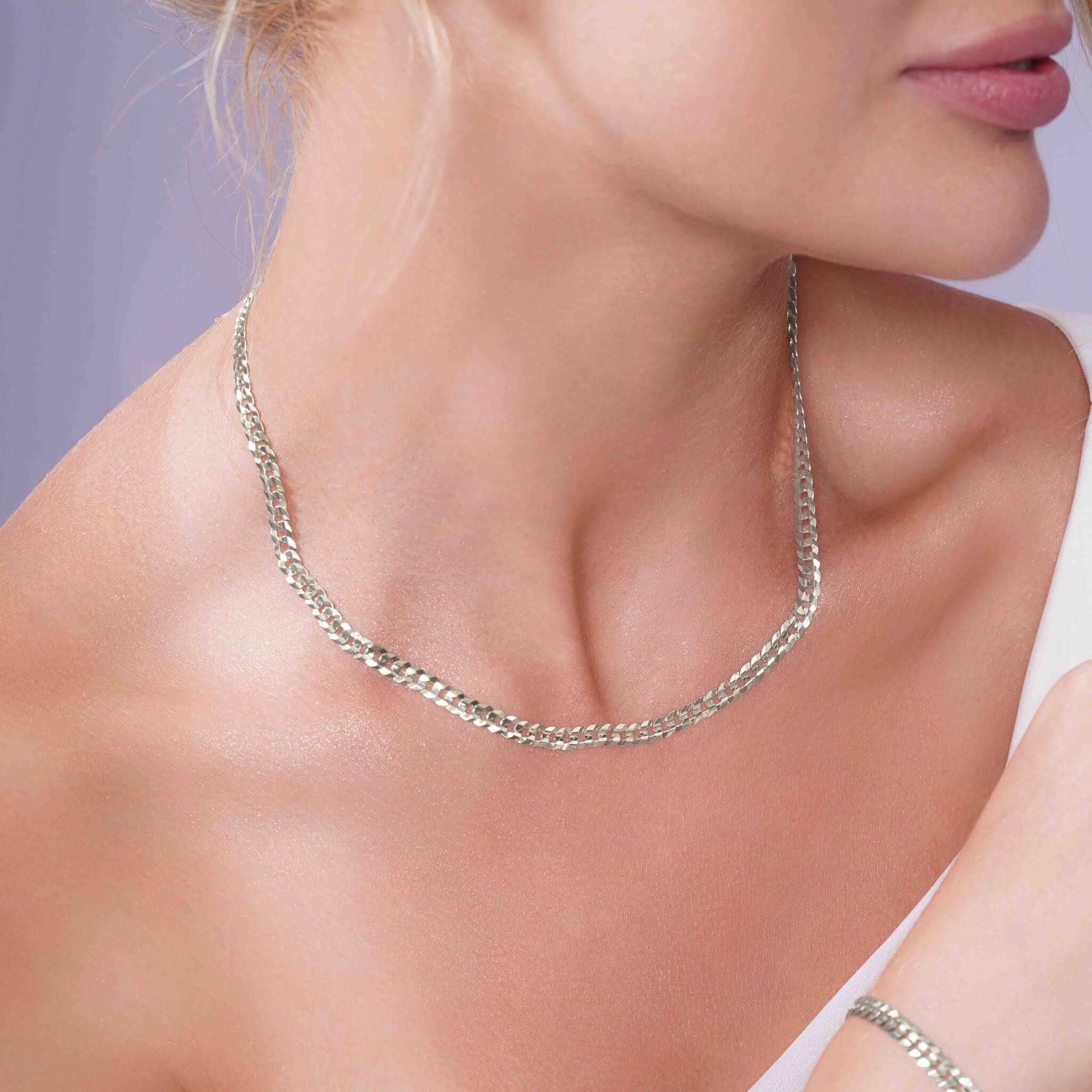 Curb Silver Chain elegantly worn by a model, showcasing its timeless design and refined elegance.