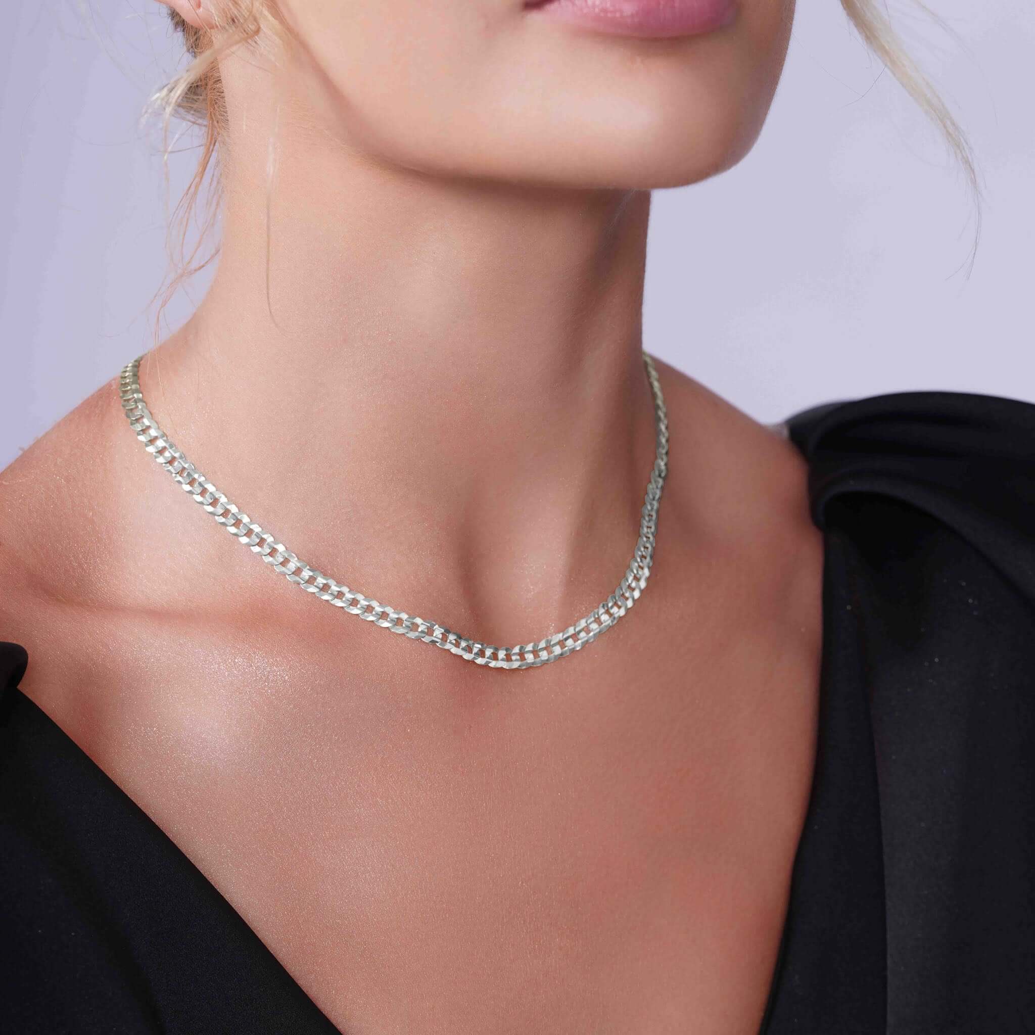 Curb Silver Chain displayed on a model, showcasing its elegant design and refined craftsmanship.