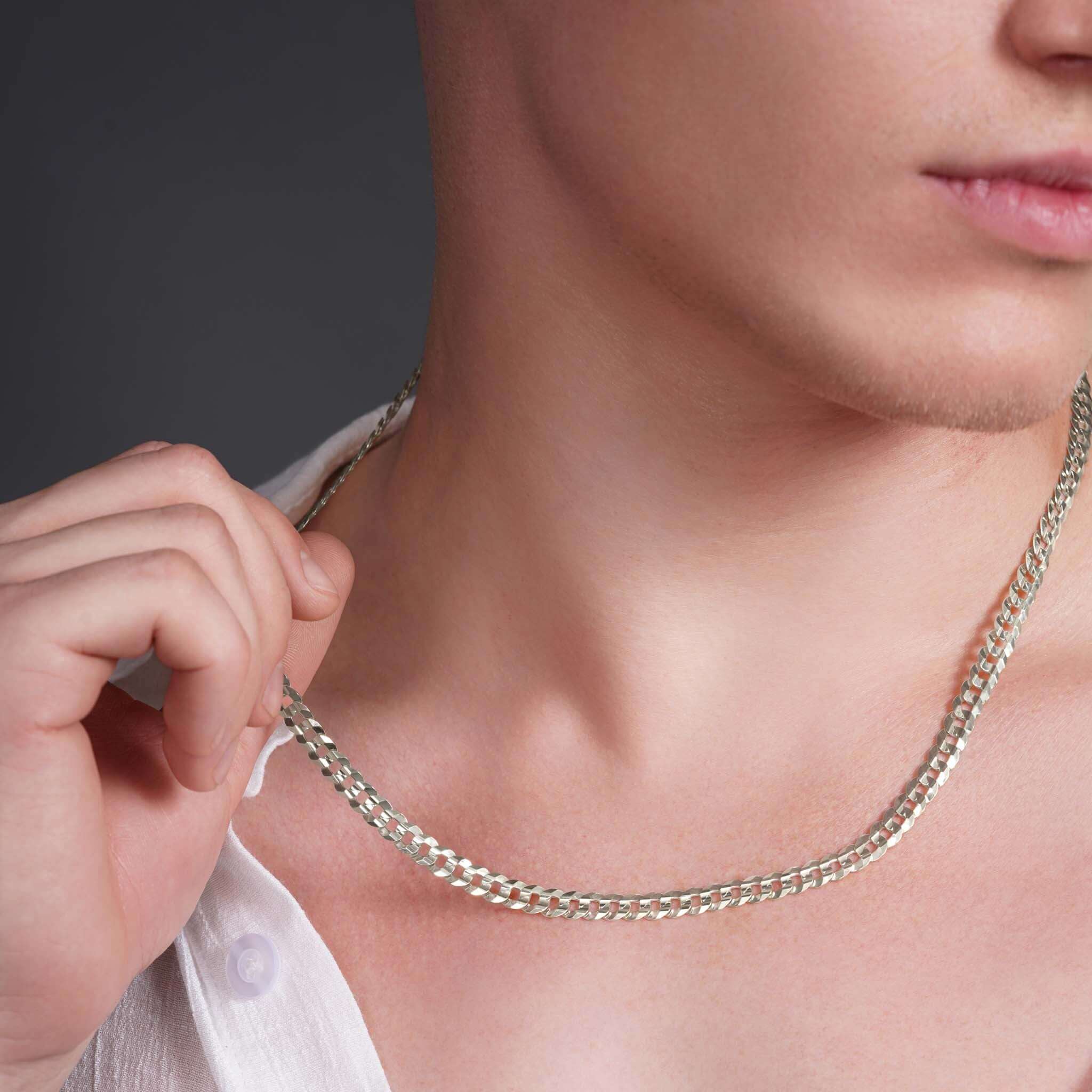 Close-up of a man wearing a Men's Curb Silver Chain, showcasing its polished interlocking links.