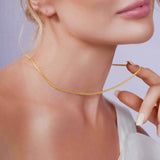 Close-up of a woman wearing the Vermeil Miami Cuban Chain, showcasing its elegant design and golden shine.