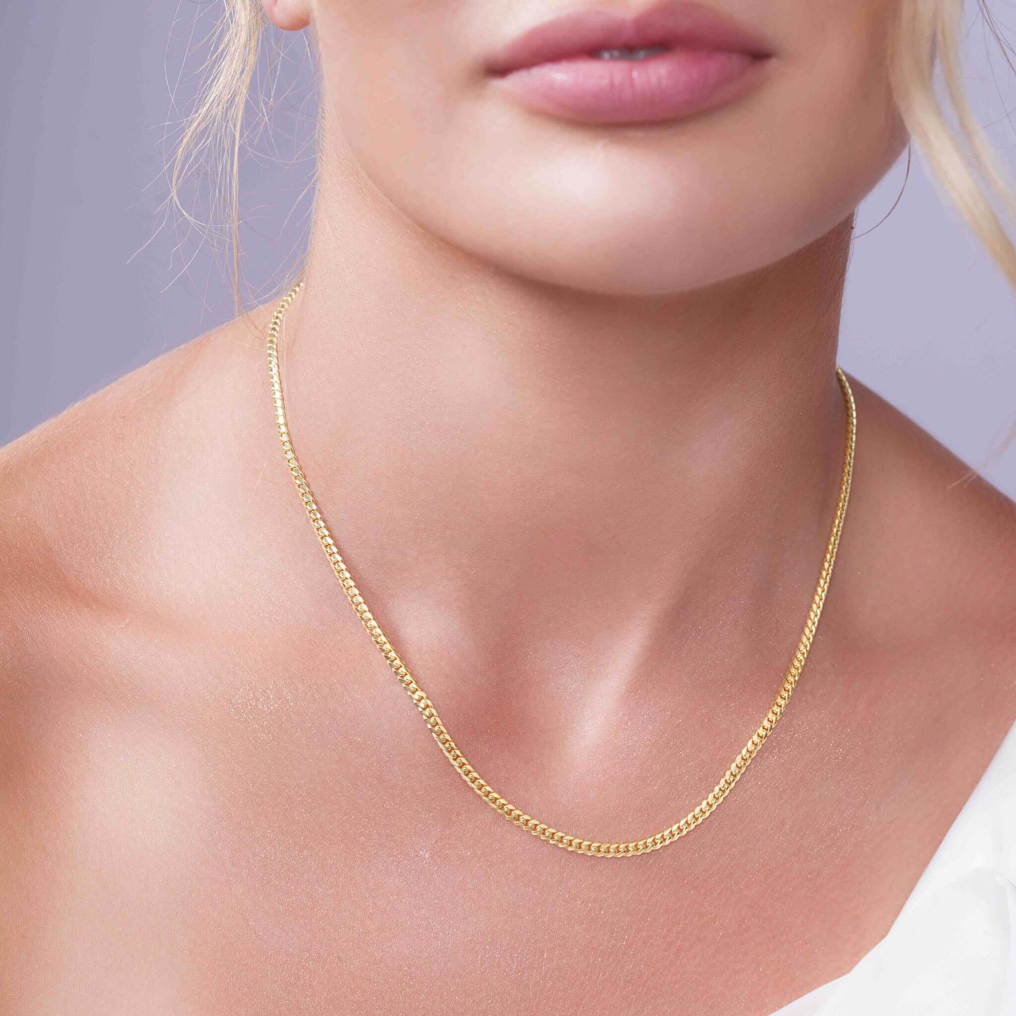 Close-up of a woman wearing a Vermeil Miami Cuban Chain, showcasing its lustrous golden hue and elegant design.