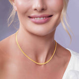 Close-up of a woman wearing a Vermeil Miami Cuban Chain, showcasing its gold plating and elegant design.