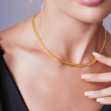 Close-up of a woman wearing the Vermeil Miami Cuban Chain, showcasing its luxurious gold finish and elegant design.
