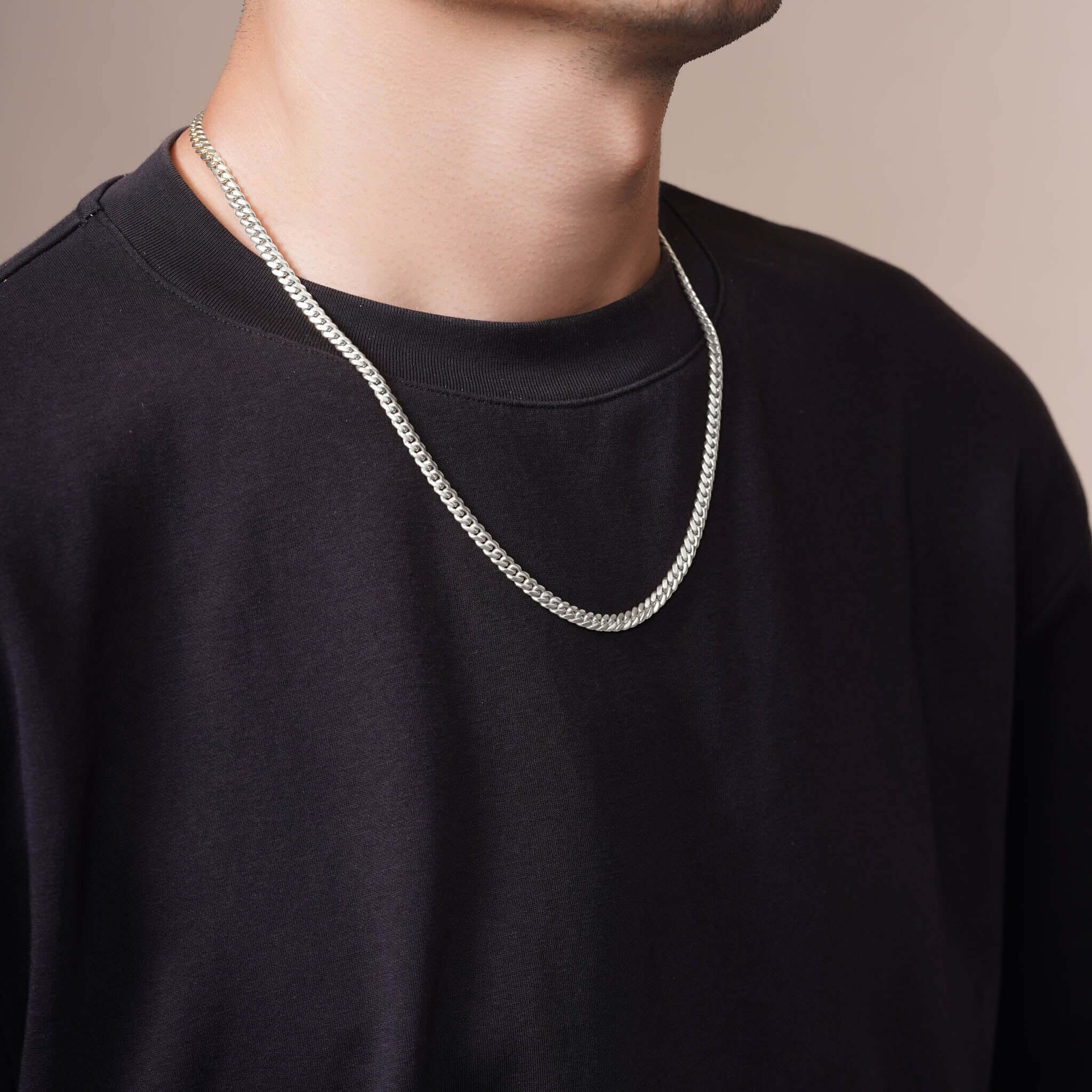 Men's Silver Miami Cuban Chain worn by a man, showcasing its sleek design and luxurious look.