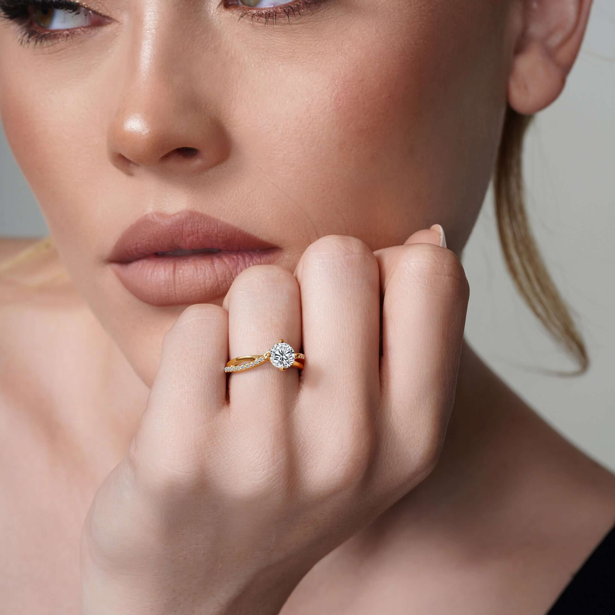 Model wearing Barkev's Twisted Lab Grown Diamond Engagement Ring with a round brilliant center stone and twisted shank in yellow gold