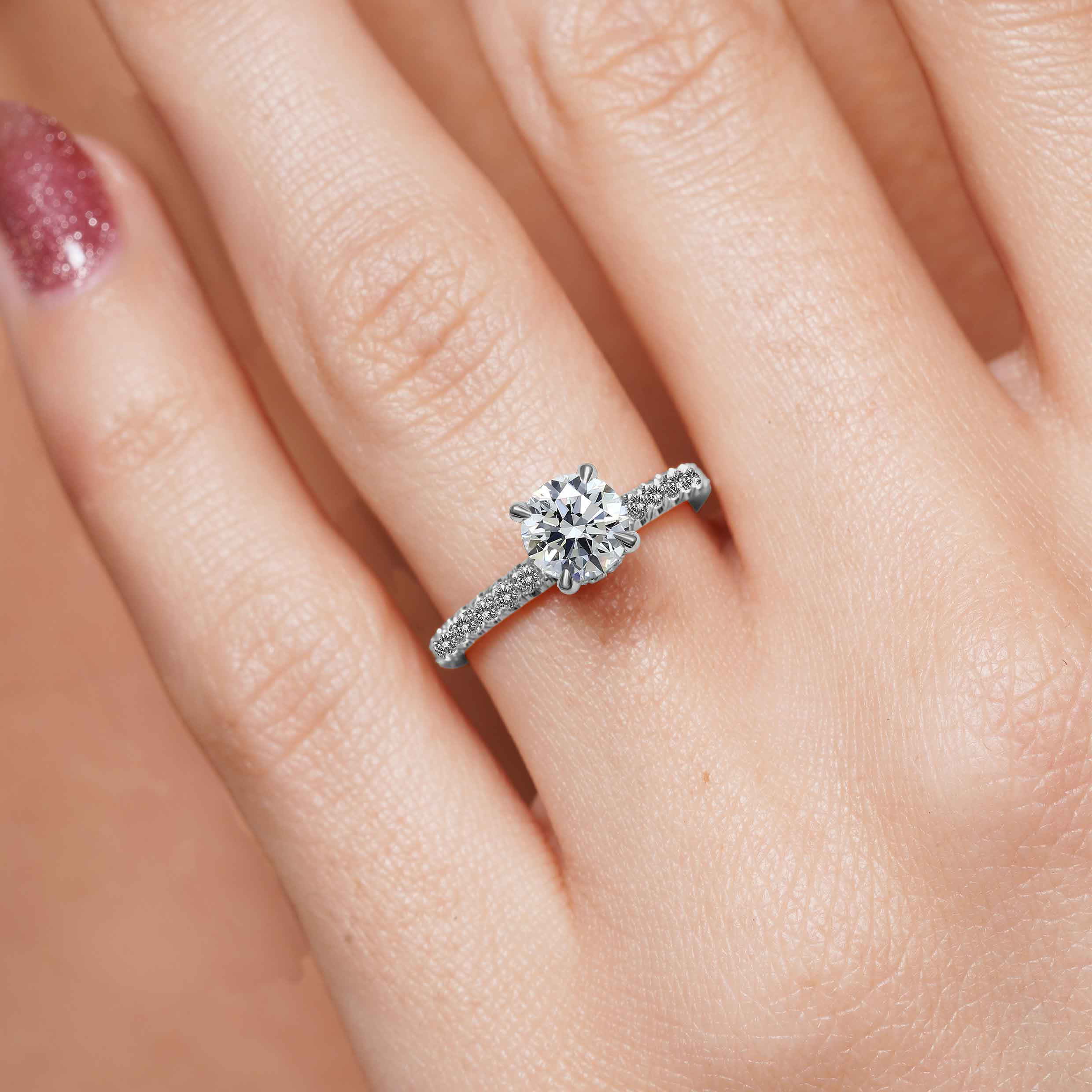 Close-up of a woman showcasing a stunning 1 carat diamond ring, highlighting its brilliance and elegance.